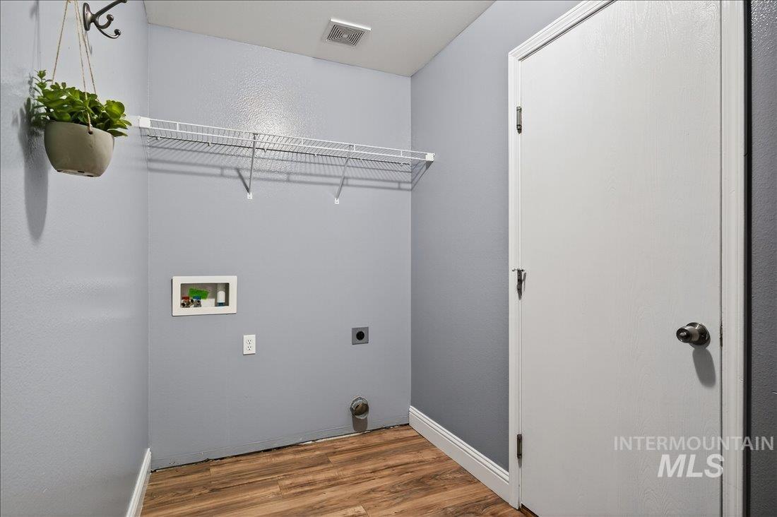 Laundry room with wood finished floors, washer hookup, and hookup for an electric dryer