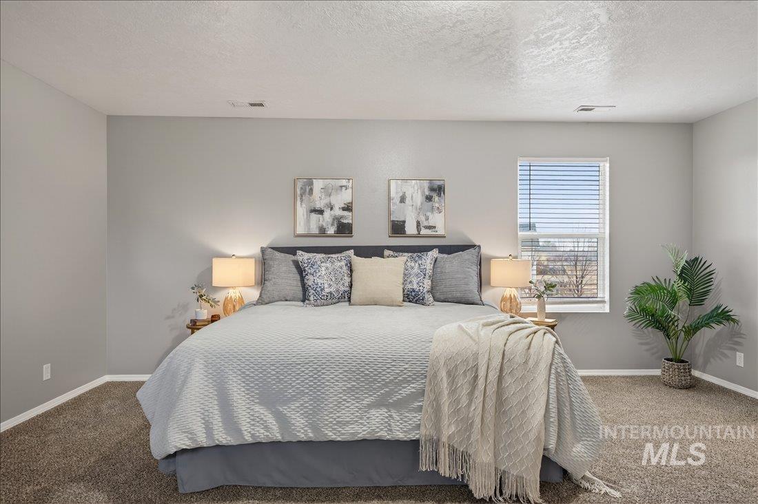Bedroom with carpet flooring and a textured ceiling