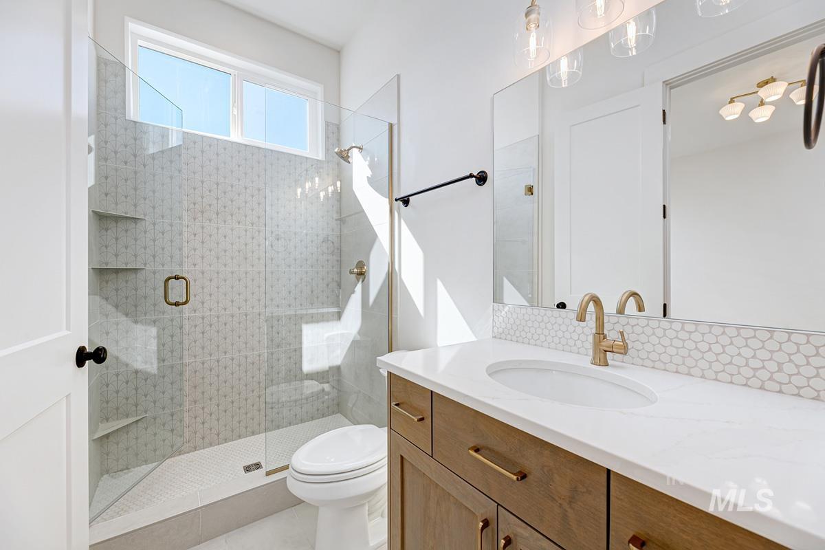 Full bath with a shower stall and vanity