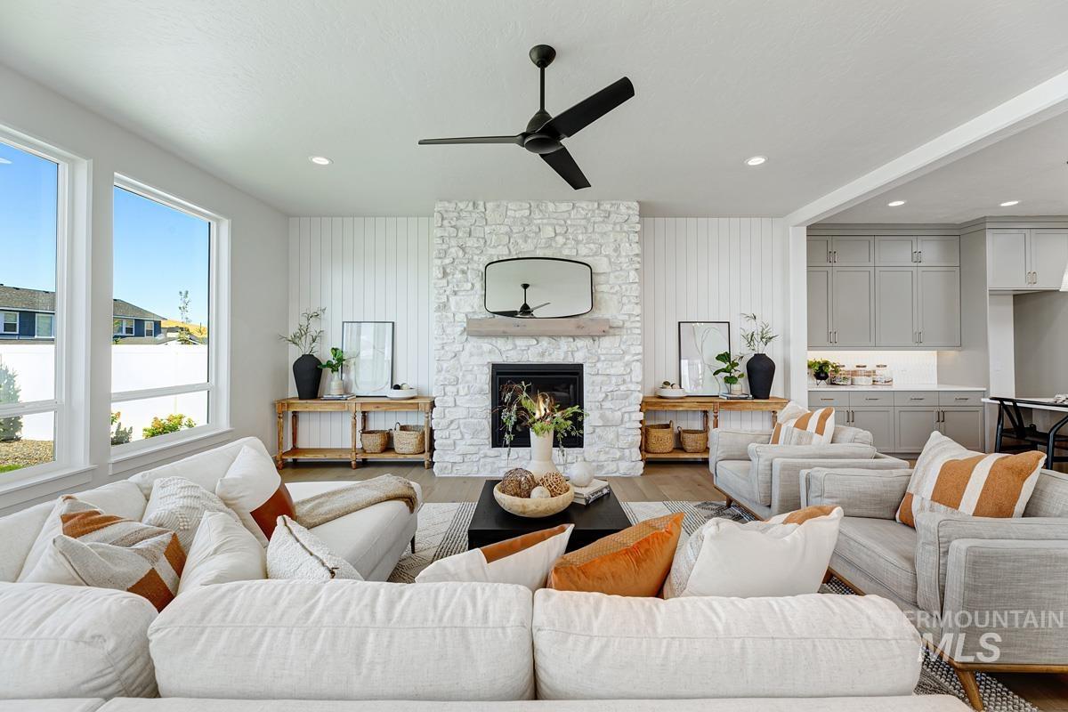 Living room featuring a fireplace, wood finished floors, ceiling fan, and recessed lighting