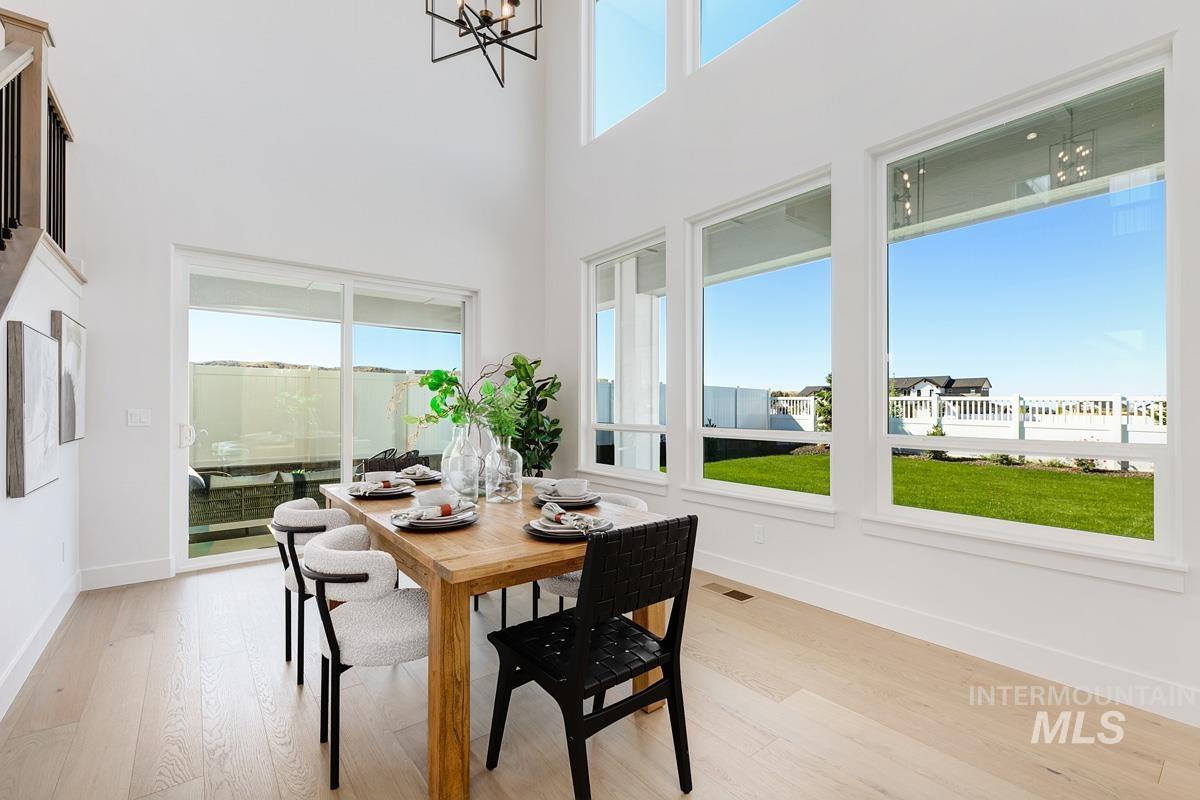 Dining area featuring a high ceiling, light wood-style floors, and a chandelier