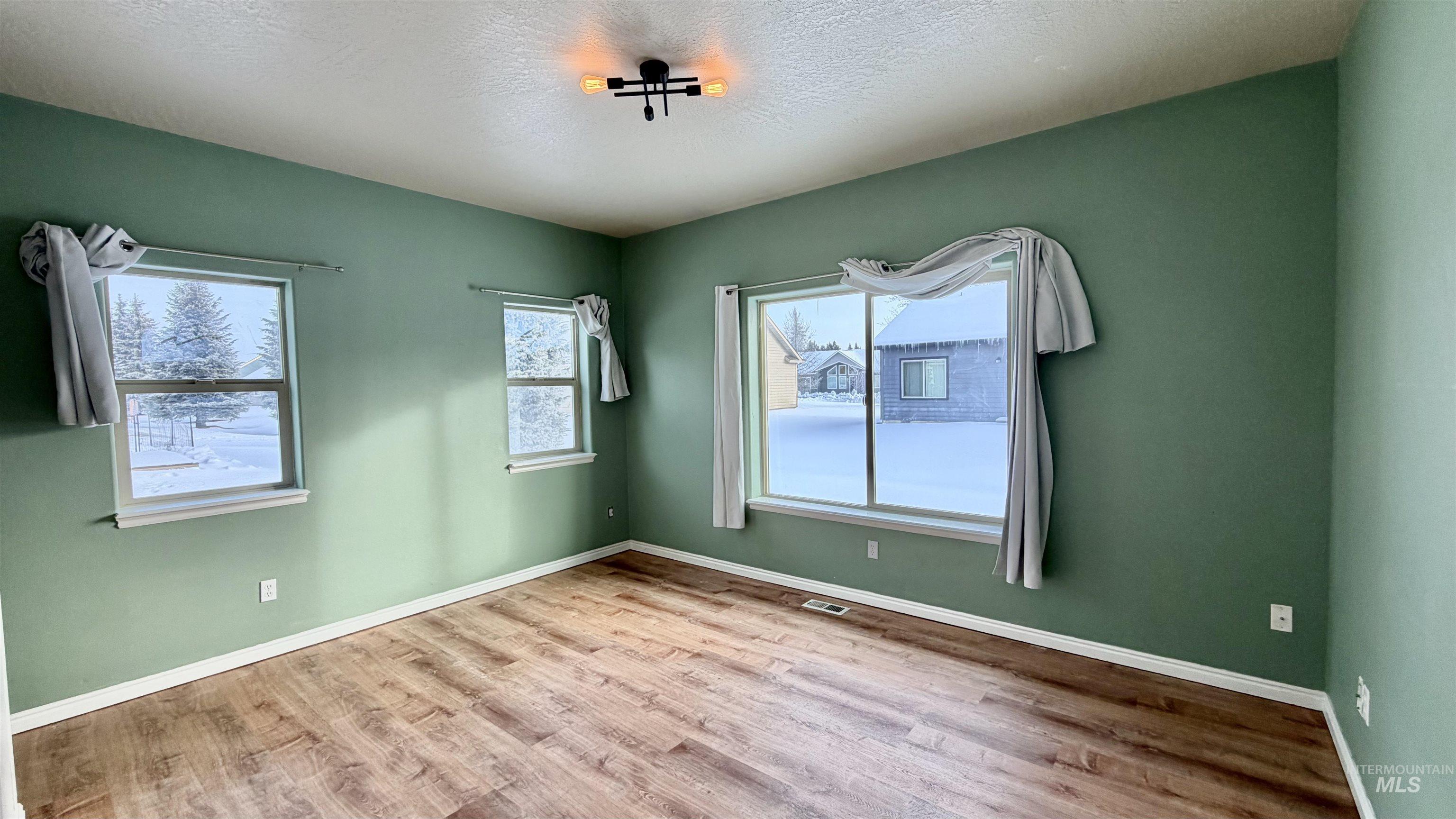 Spare room with wood finished floors and a textured ceiling