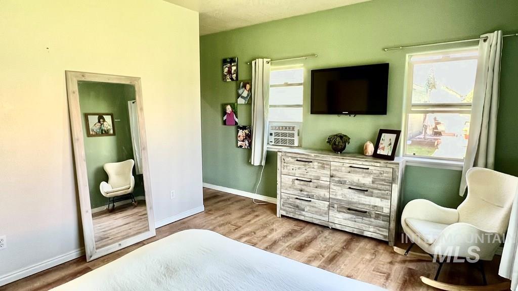 Bedroom with light wood-type flooring and cooling unit