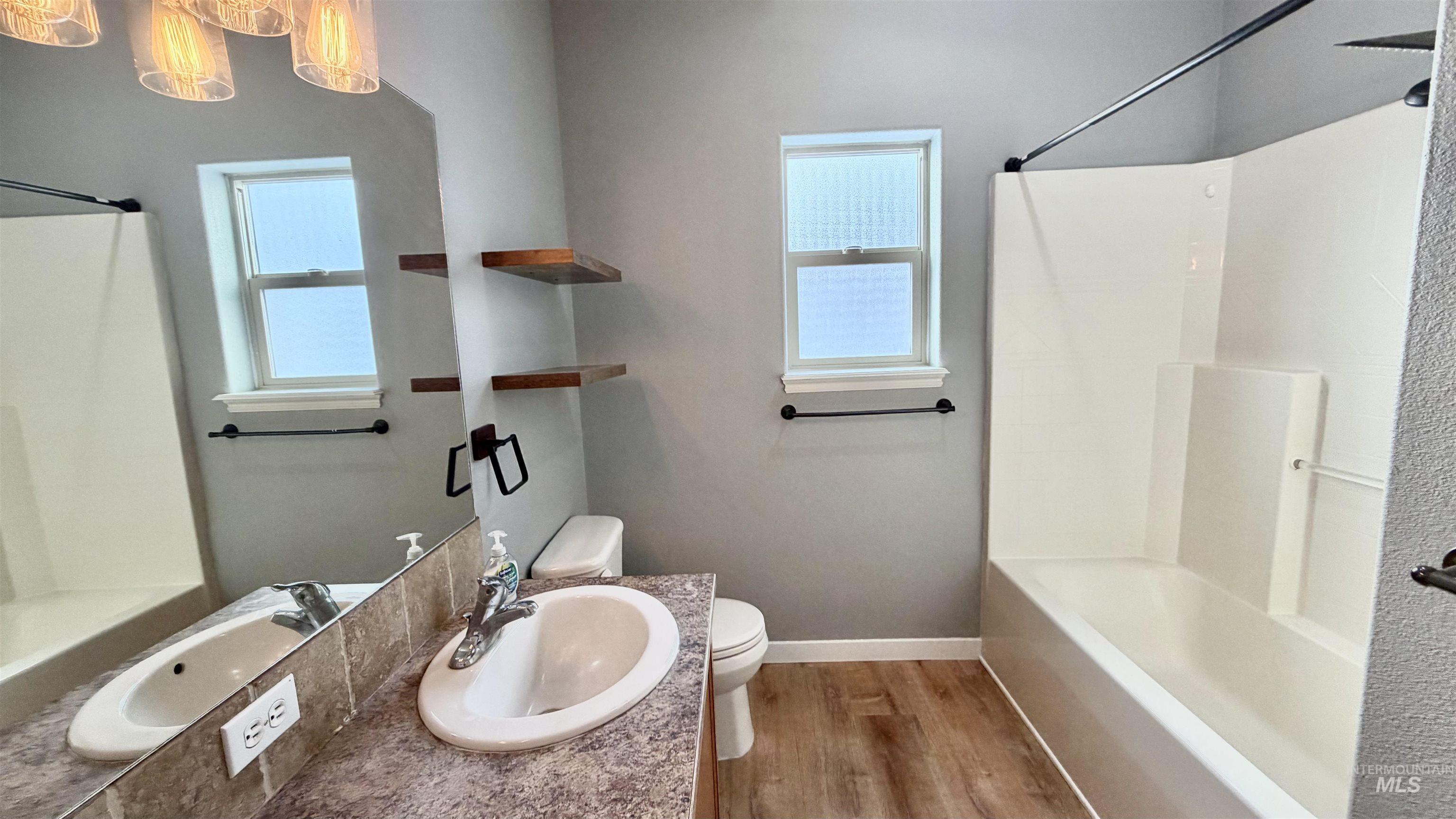 Bathroom featuring shower / tub combination, vanity, and light wood-type flooring