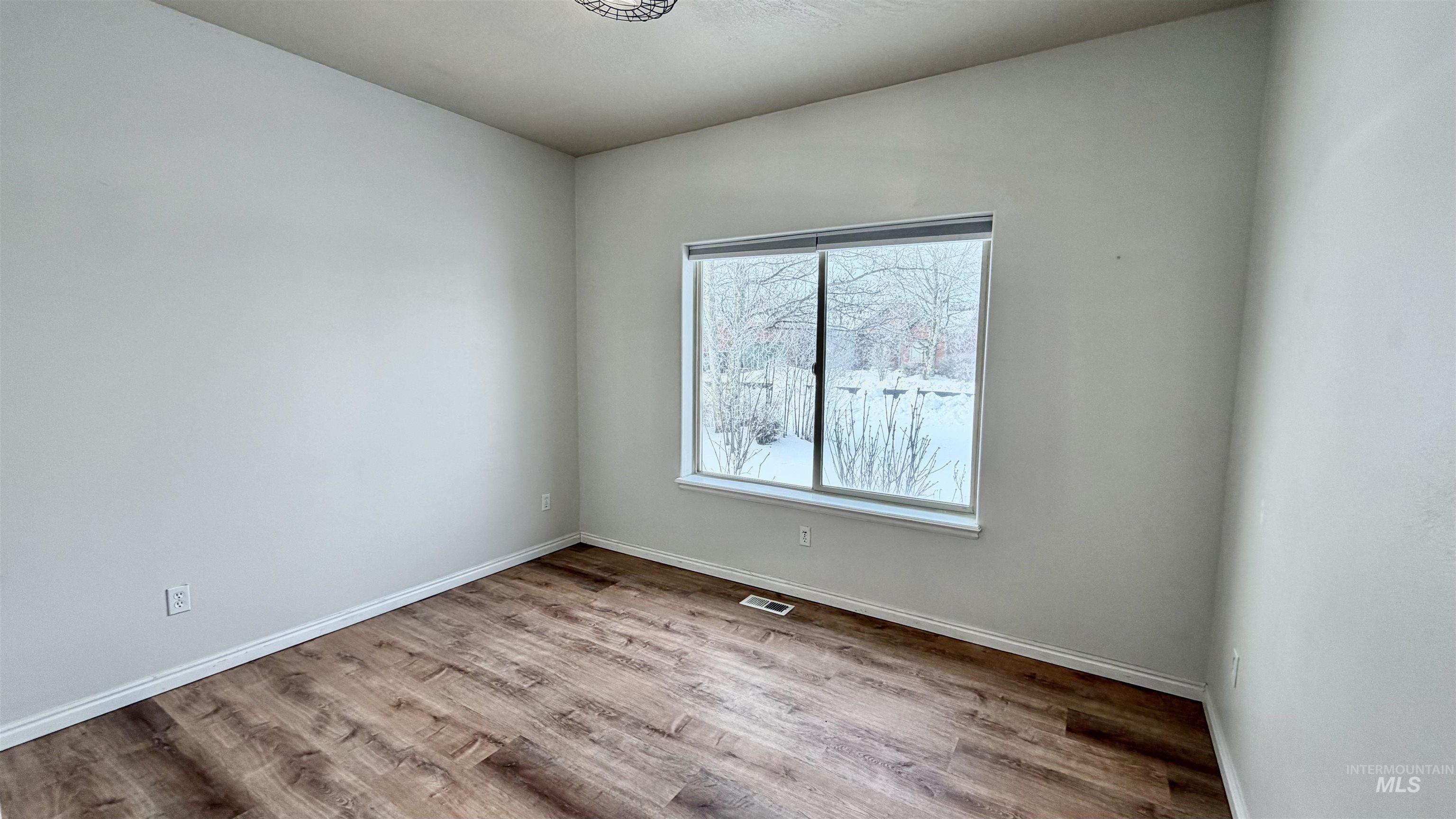Spare room with light wood-style flooring and baseboards