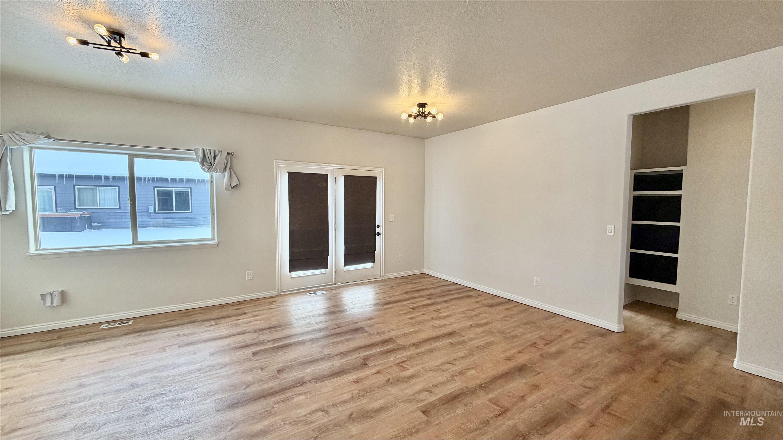 Empty room featuring a textured ceiling and light wood-type flooring