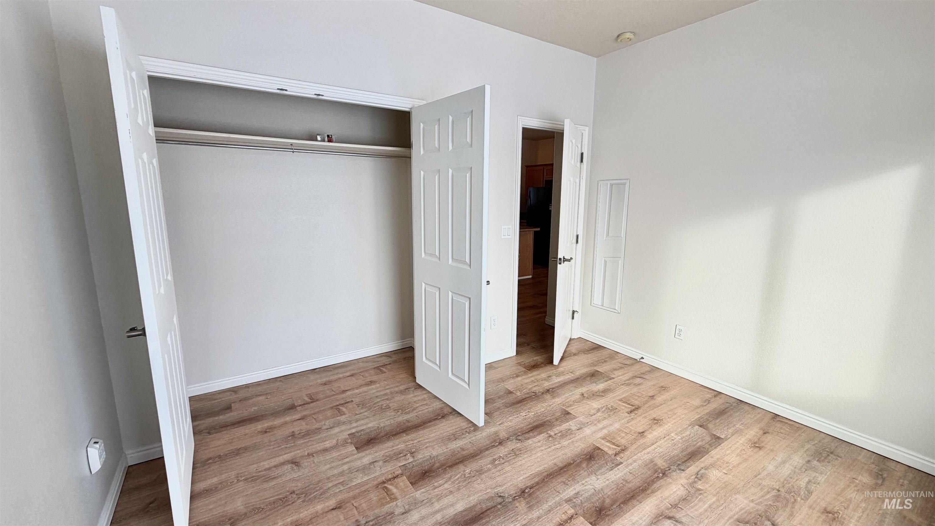 Unfurnished bedroom featuring light wood-type flooring and a closet