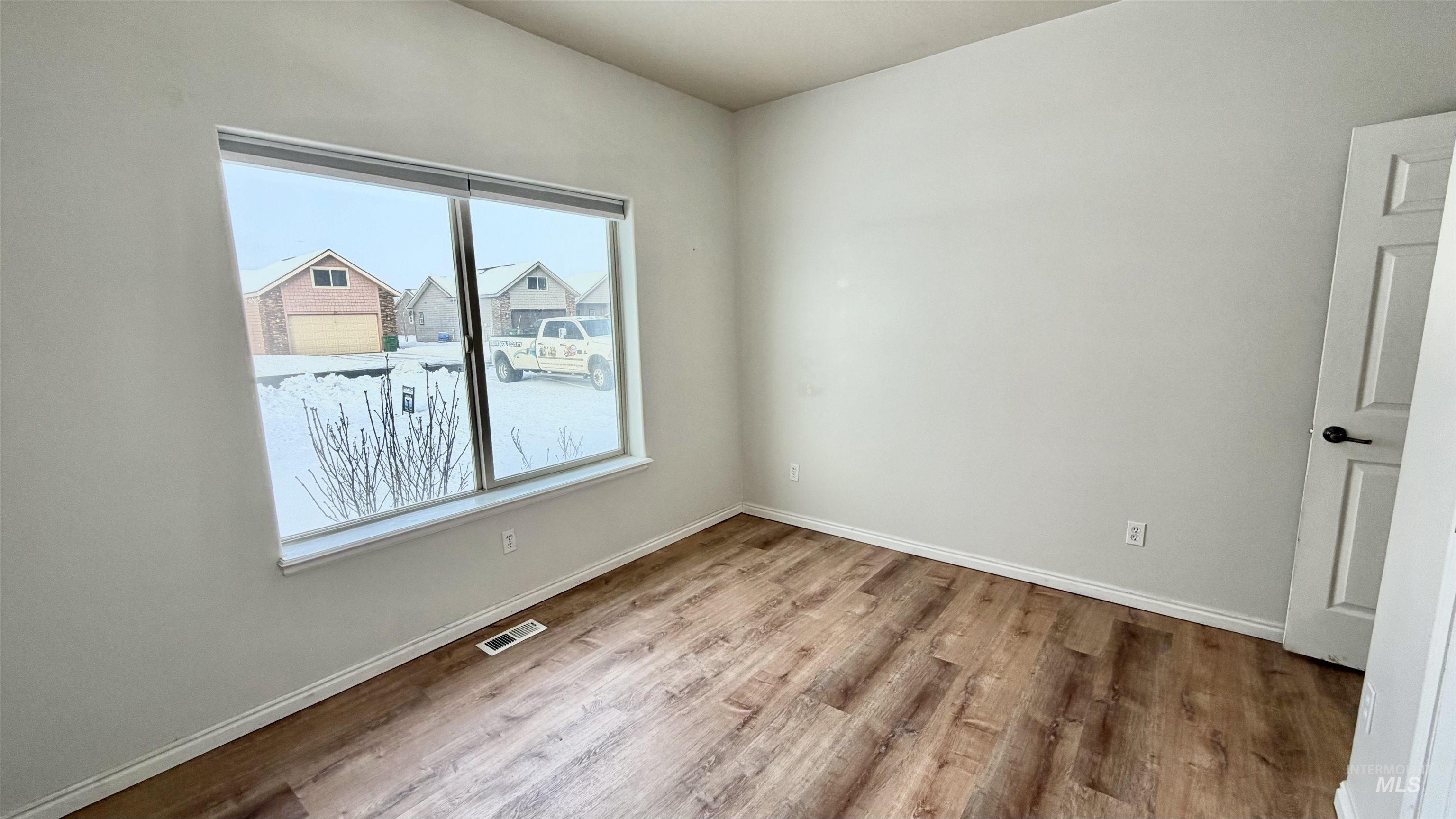 Empty room featuring light wood finished floors and baseboards