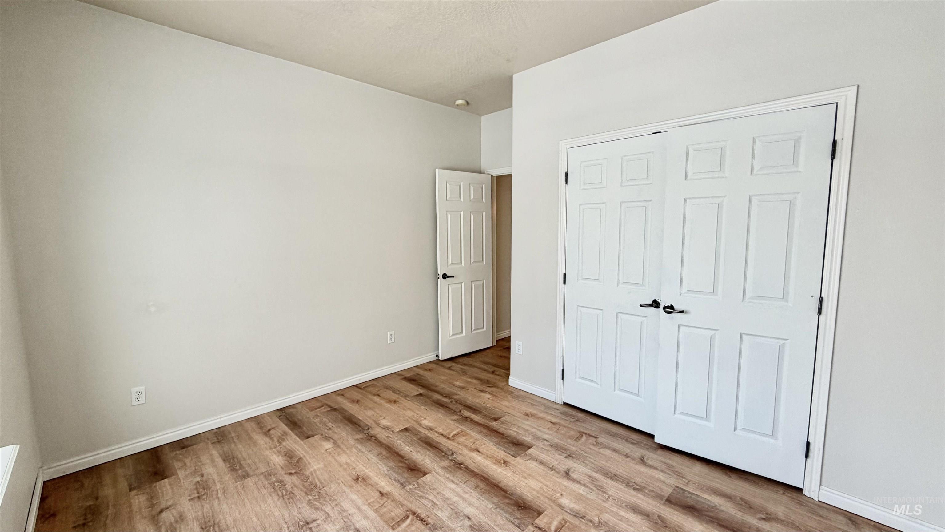 Unfurnished bedroom with light wood-type flooring and a closet