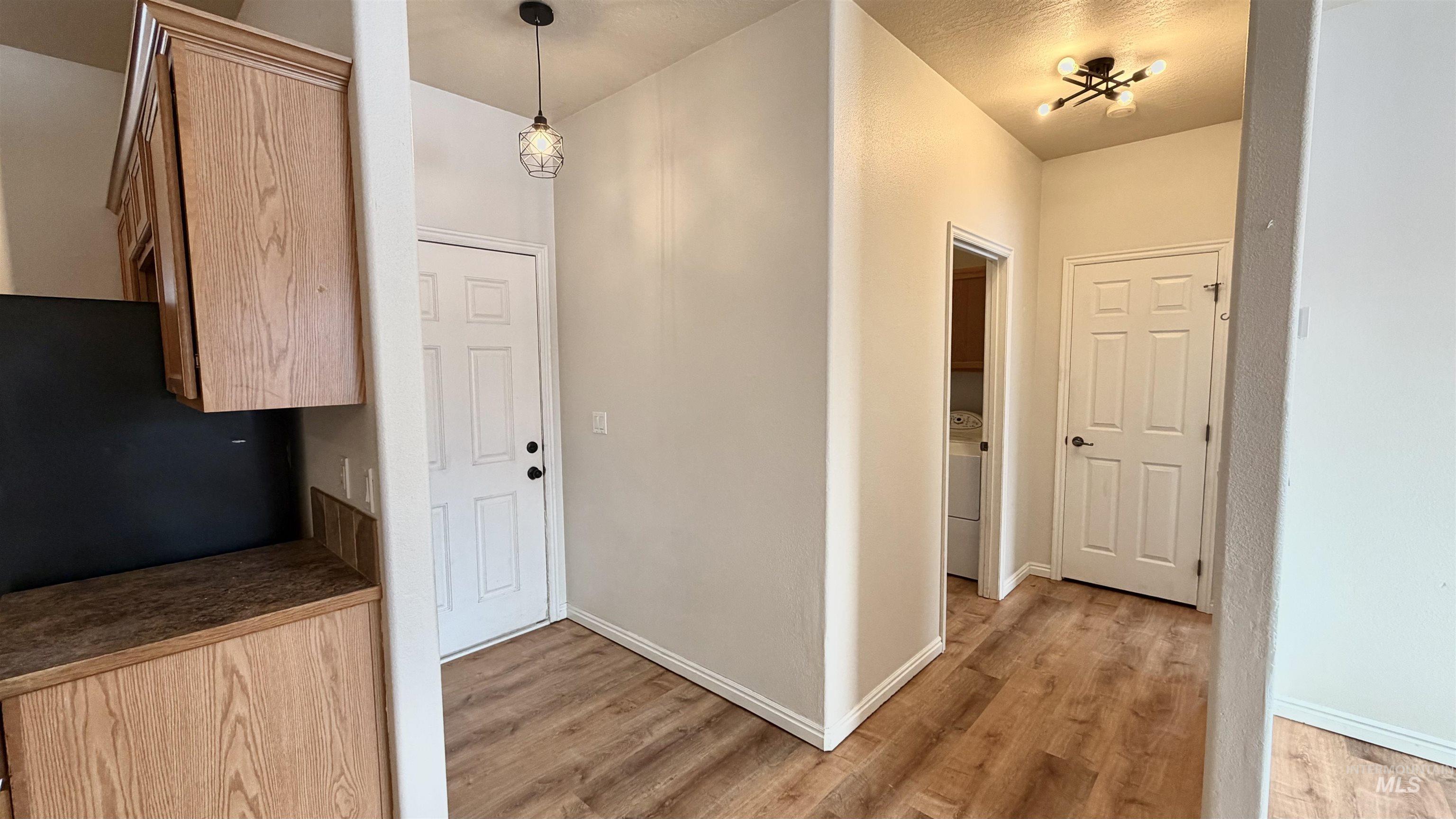 Hall featuring light wood finished floors and washer / clothes dryer