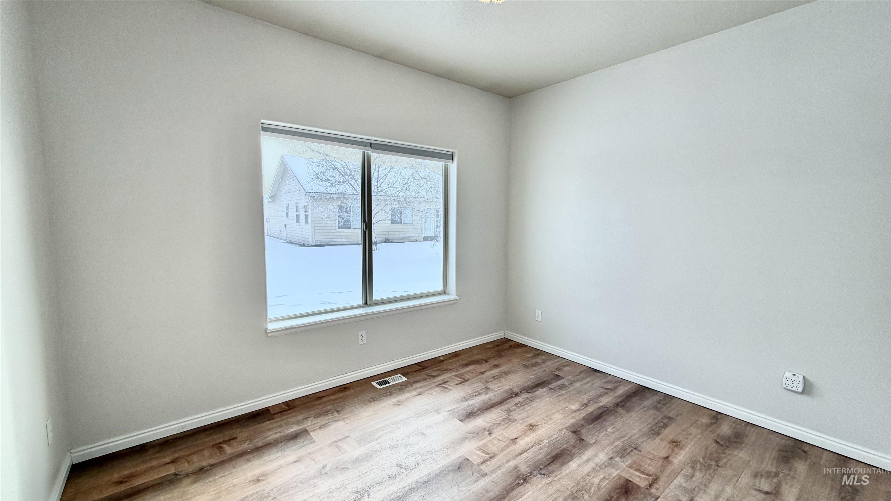 Unfurnished room featuring light wood-type flooring and baseboards