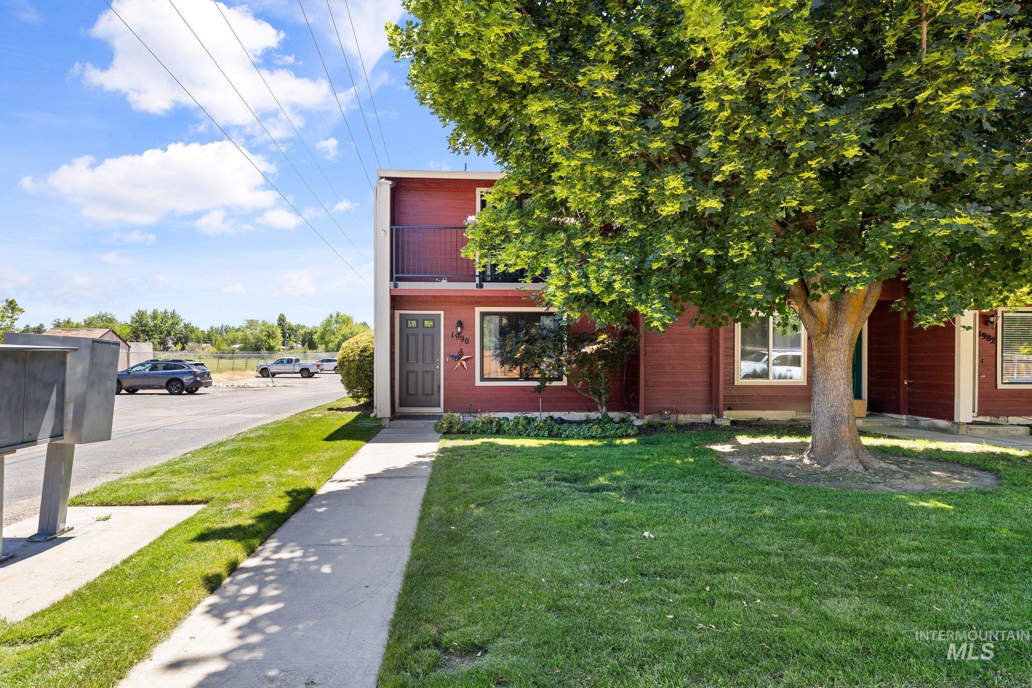View of front of home with a front yard and a balcony