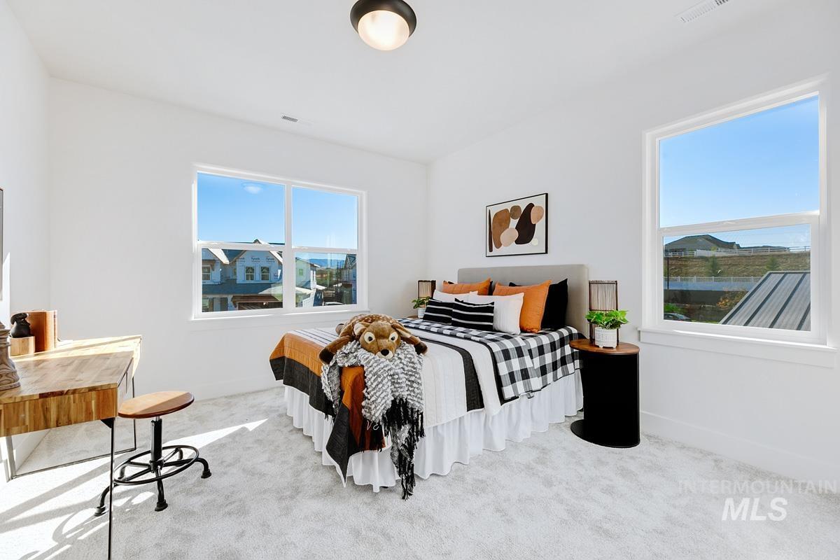 Bedroom featuring carpet and multiple windows