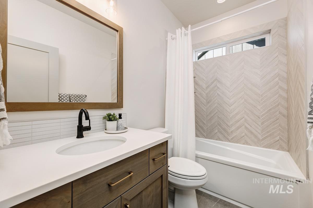 Full bath with shower / bathtub combination with curtain, vanity, and tile patterned flooring