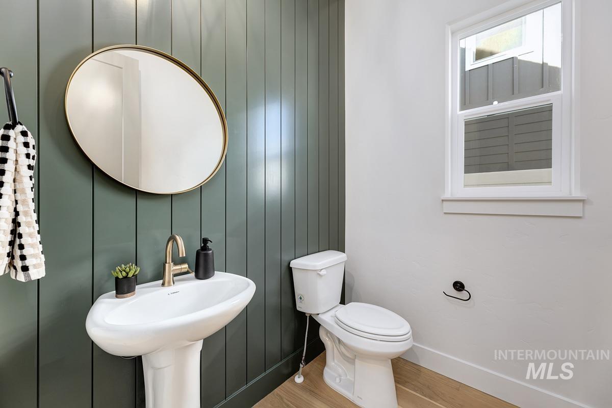 Half bath with wood finished floors and toilet