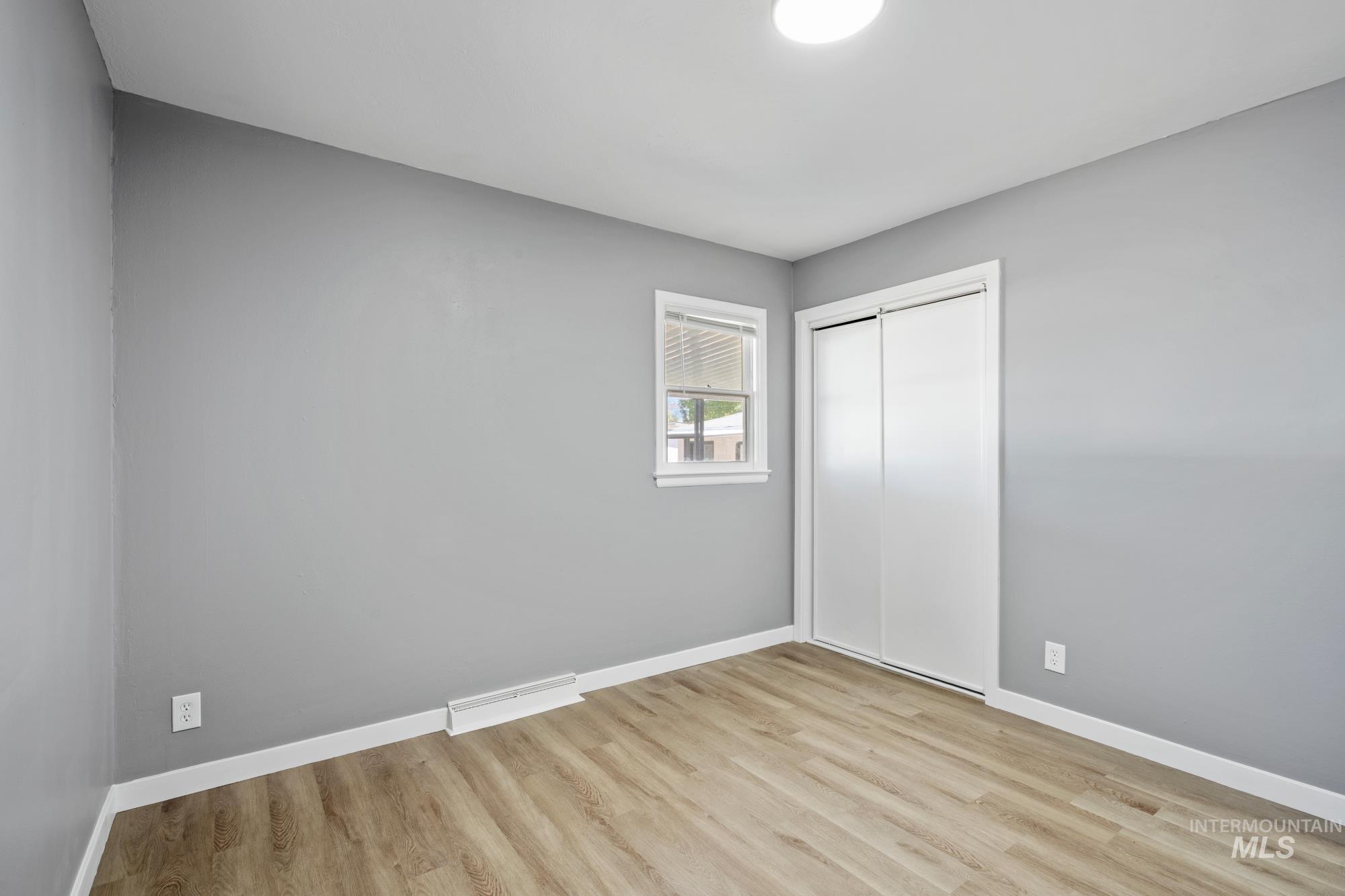 Unfurnished bedroom with light wood-type flooring and a closet