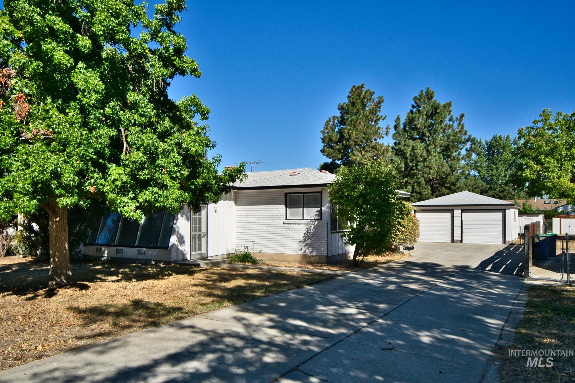 View of front of property with a garage and an outdoor structure