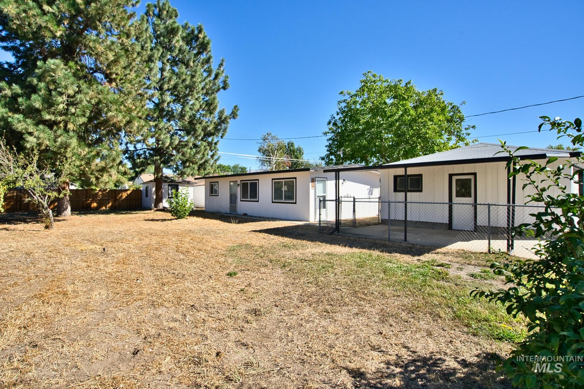 Back of house with a fenced backyard and a patio