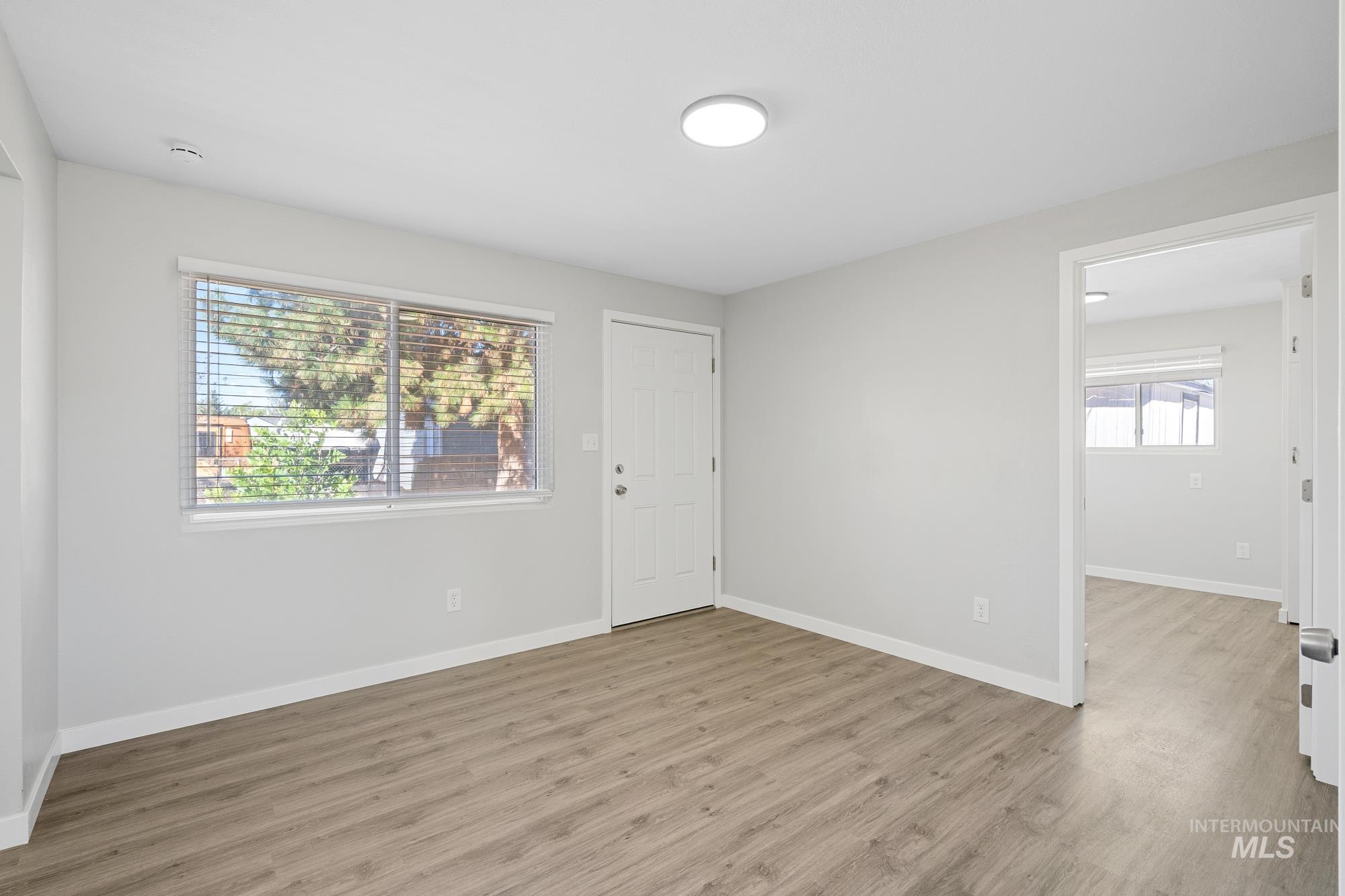 Empty room with light wood-type flooring and baseboards