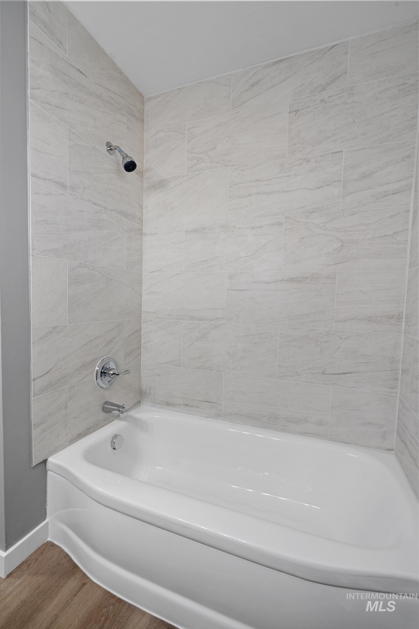 Bathroom with shower / tub combination and wood finished floors