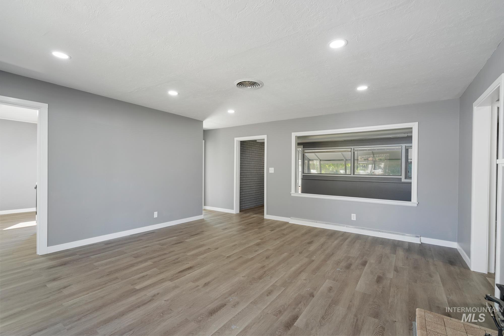 Unfurnished living room with light wood finished floors and recessed lighting