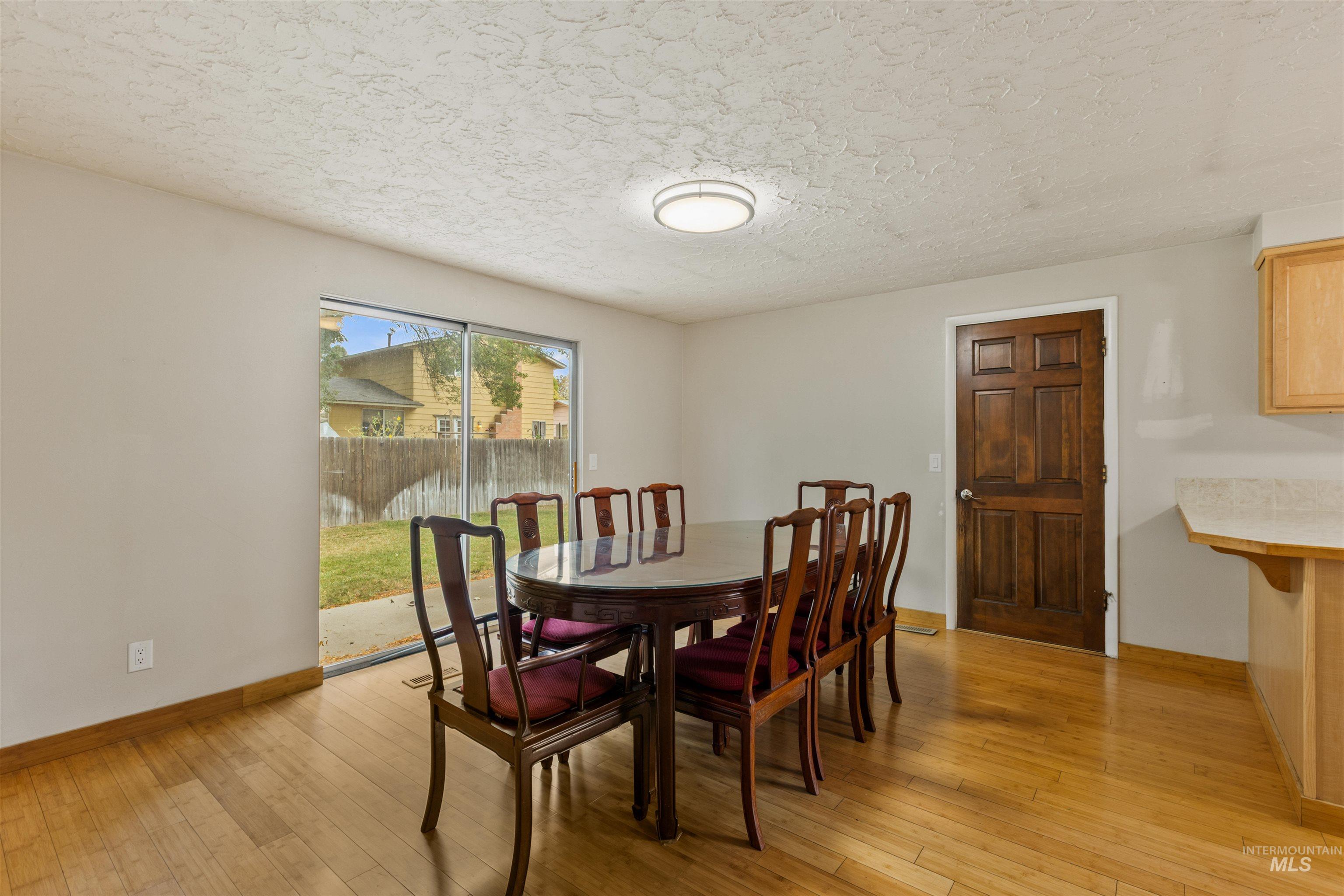 Dining area featuring light wood finished floors and a textured ceiling