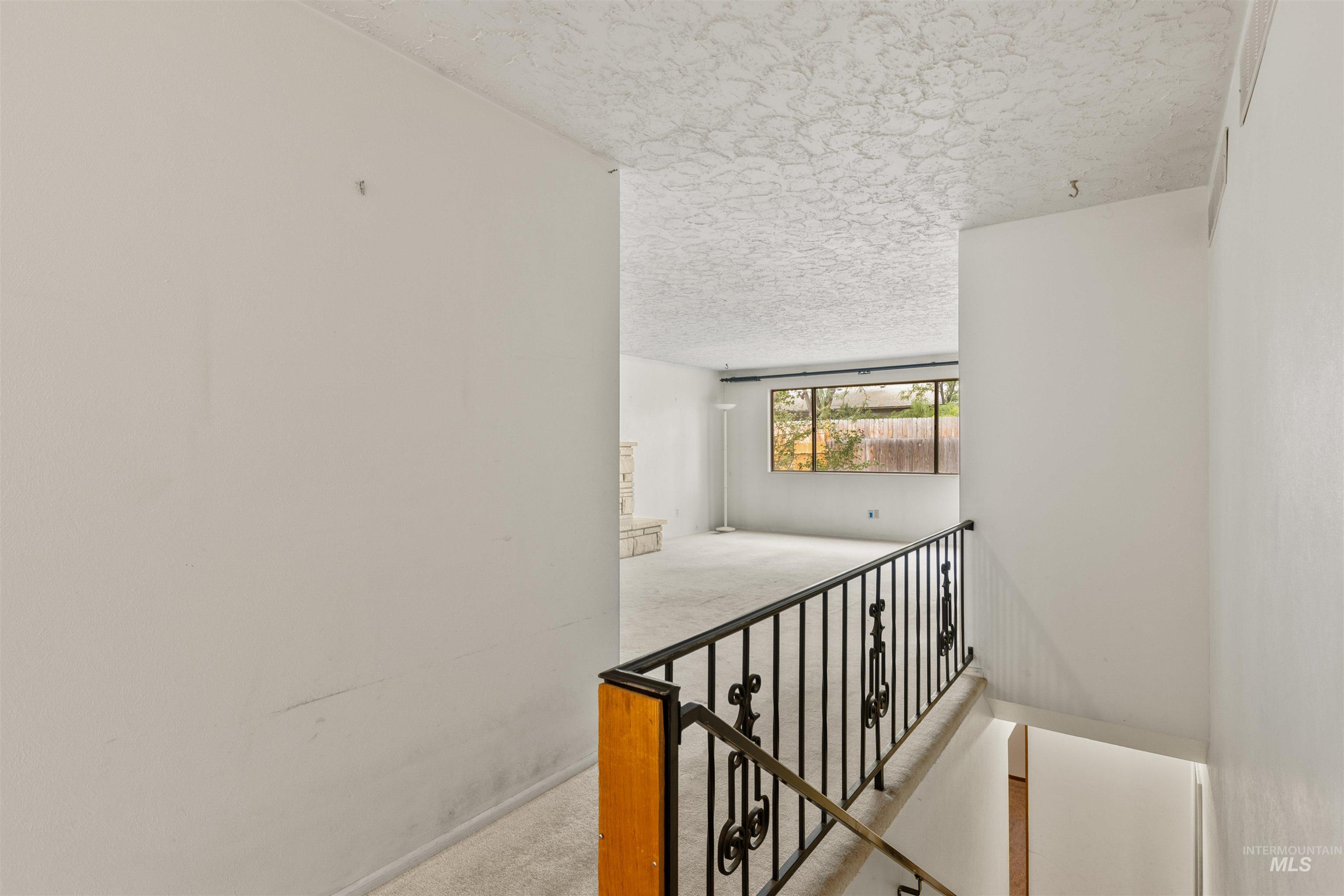 Staircase with carpet and a textured ceiling