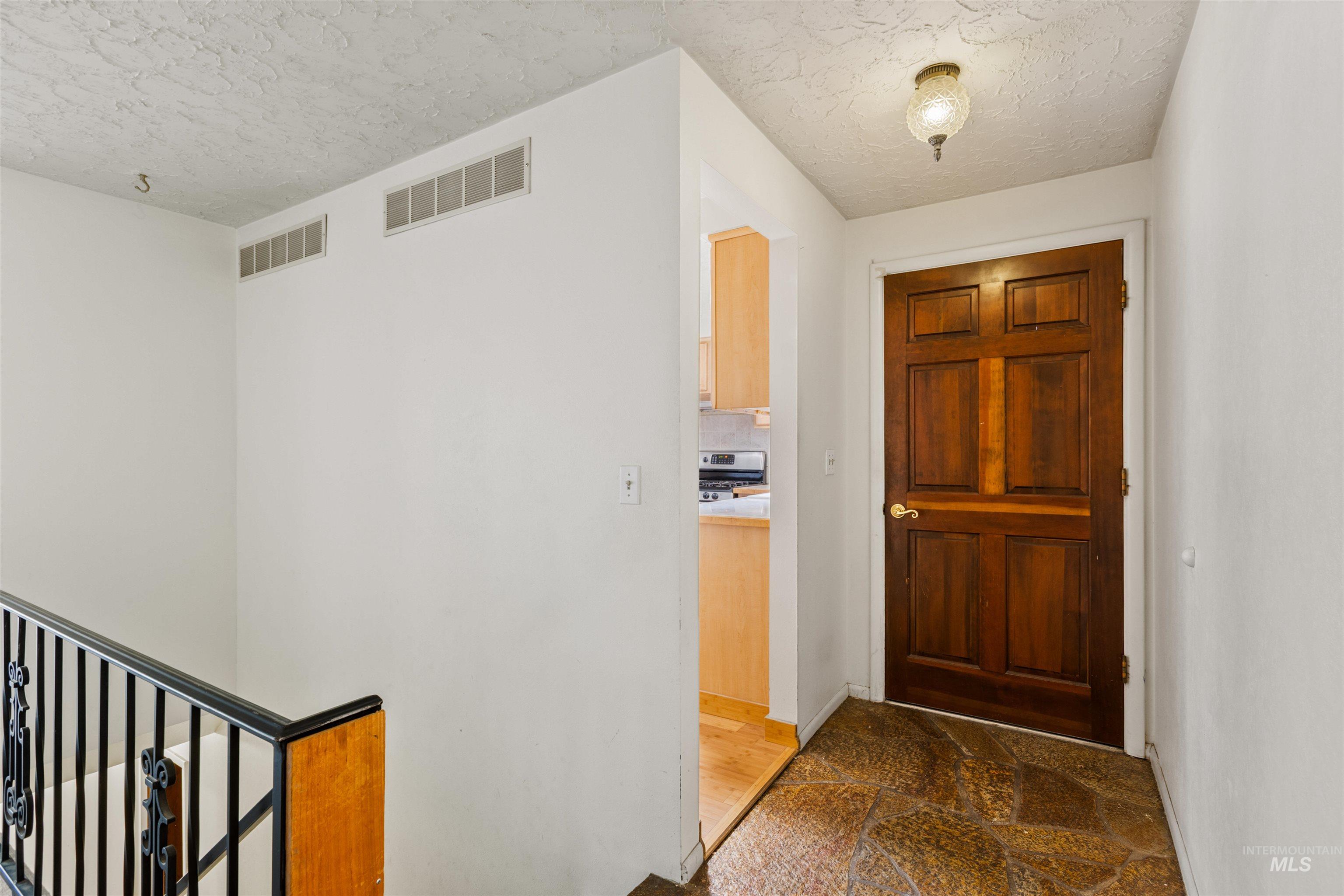 Hallway featuring a textured ceiling and baseboards