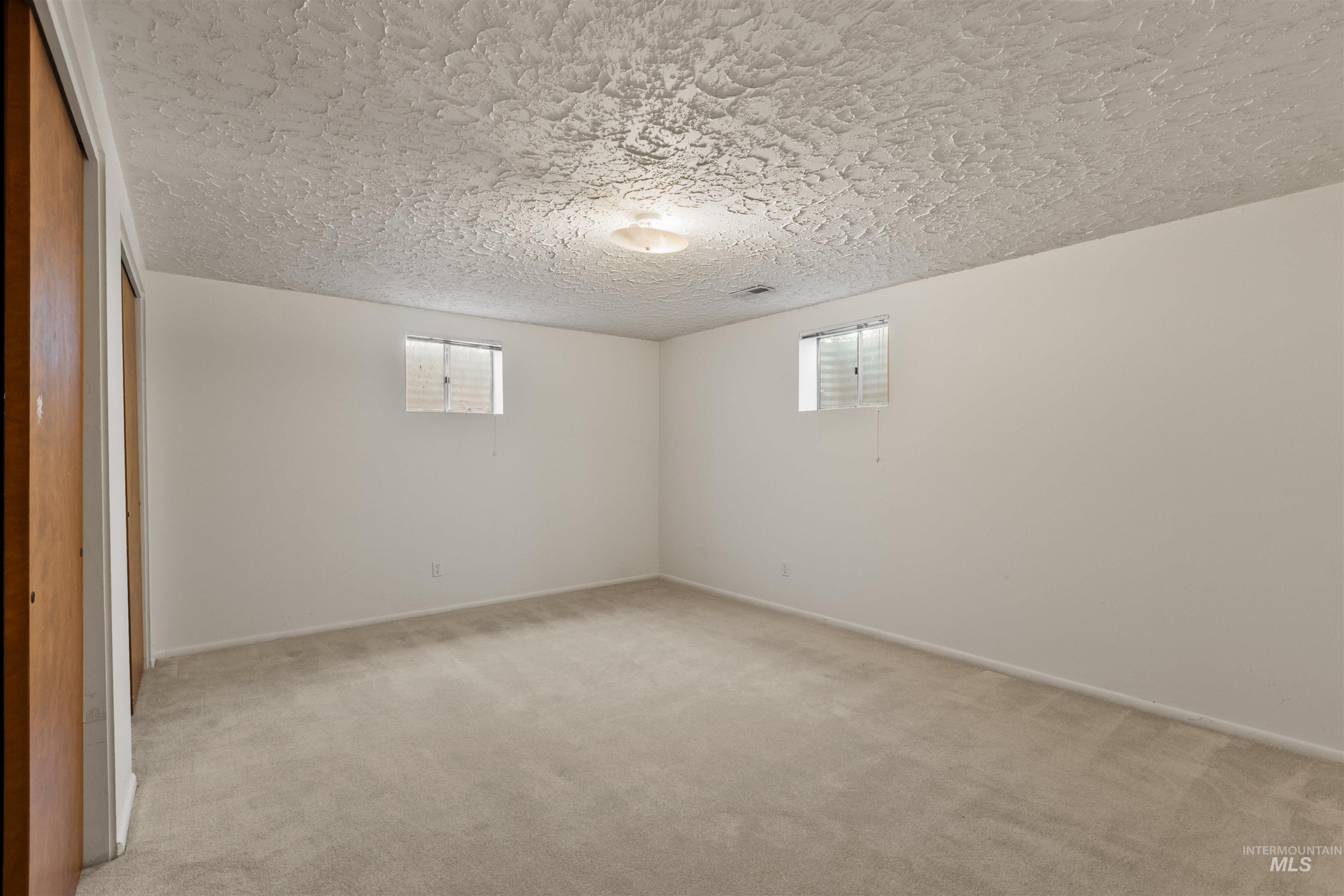 Spare room with light carpet and a textured ceiling