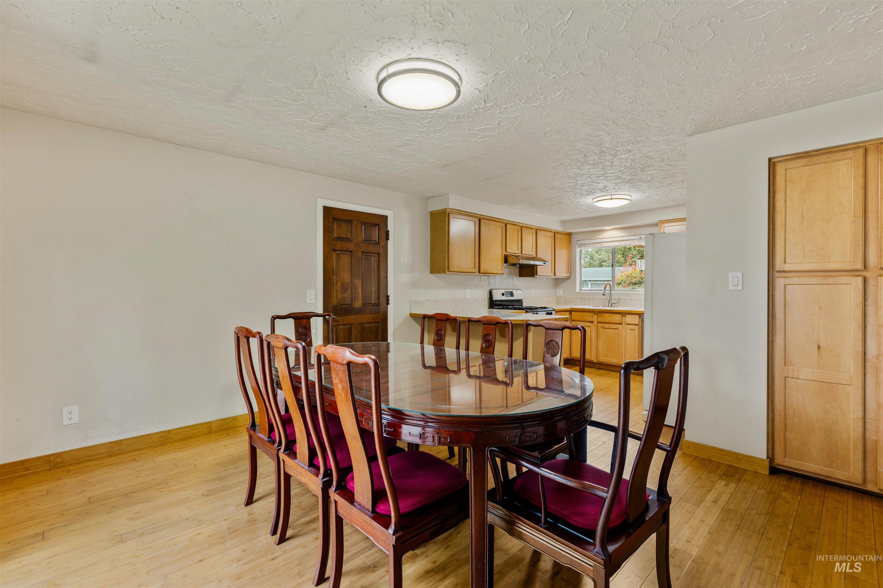 Dining room featuring light wood-style flooring and a textured ceiling
