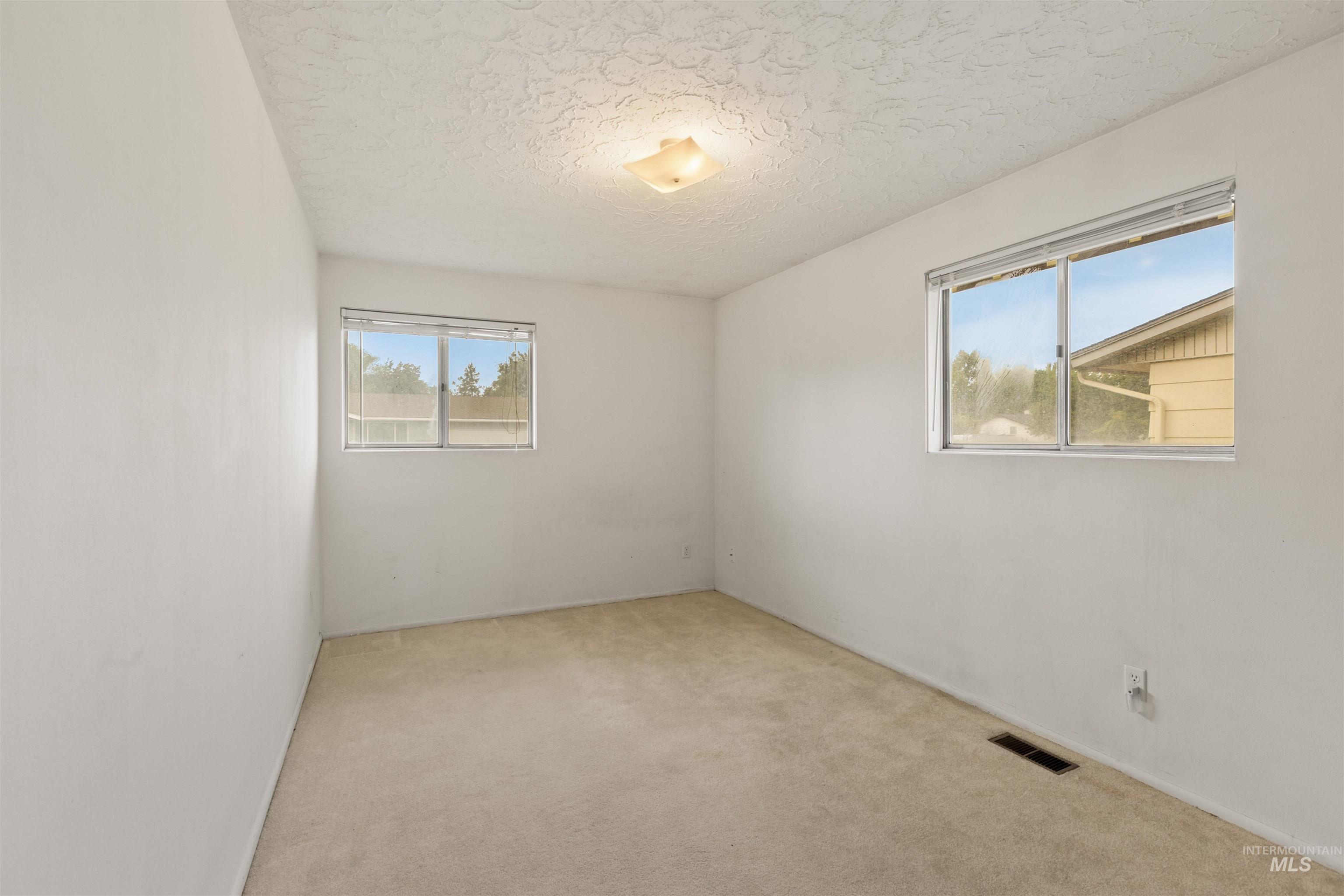 Carpeted empty room with a textured ceiling