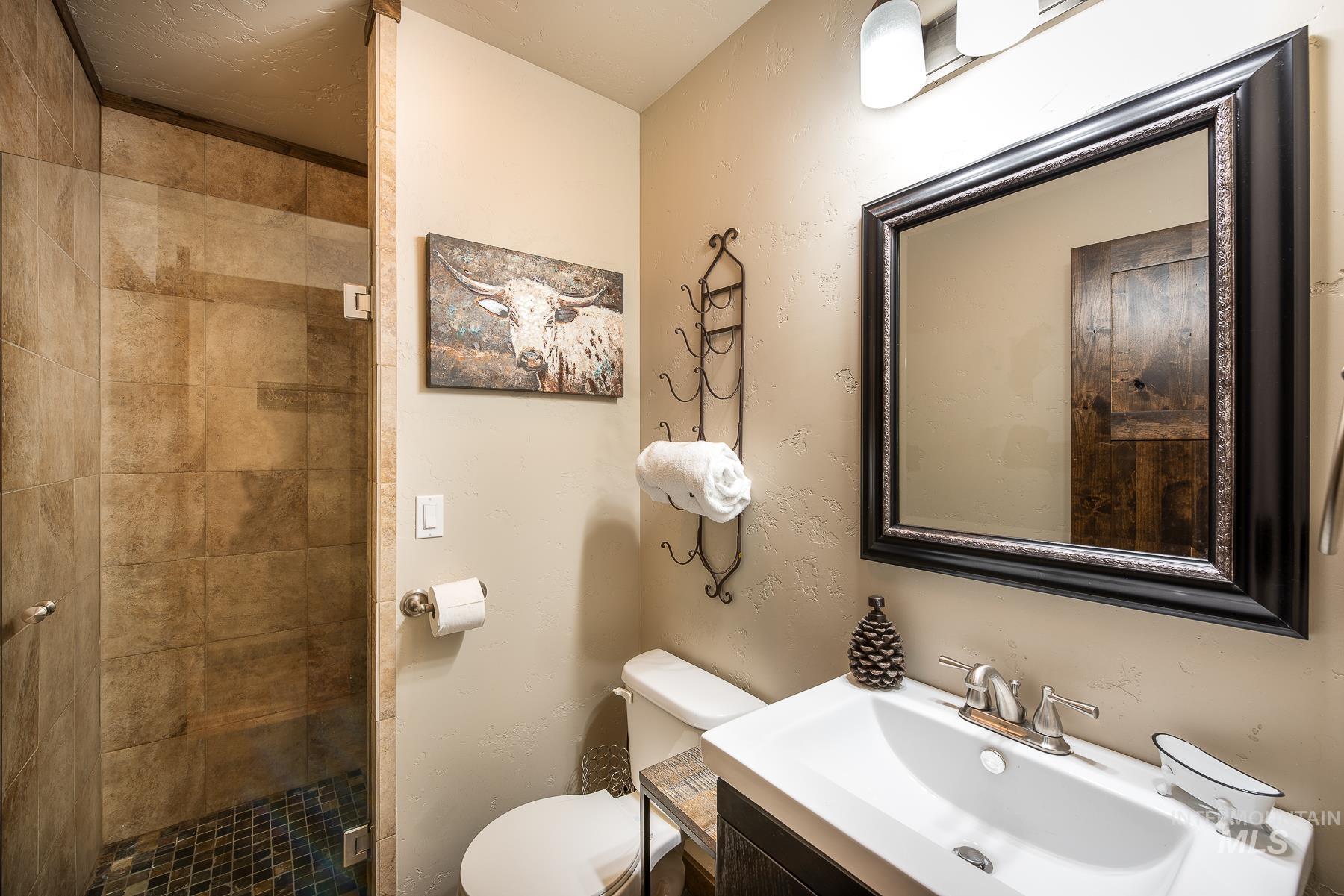 Bathroom with vanity, a shower stall, and a textured wall