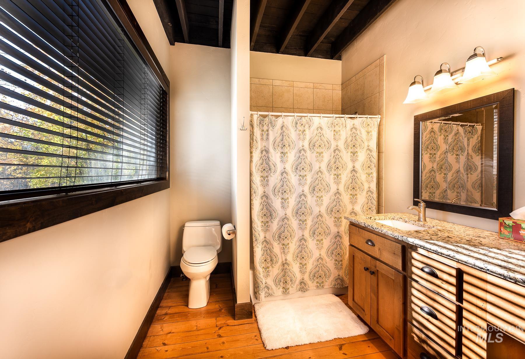 Bathroom featuring a shower stall, vanity, and light wood-type flooring