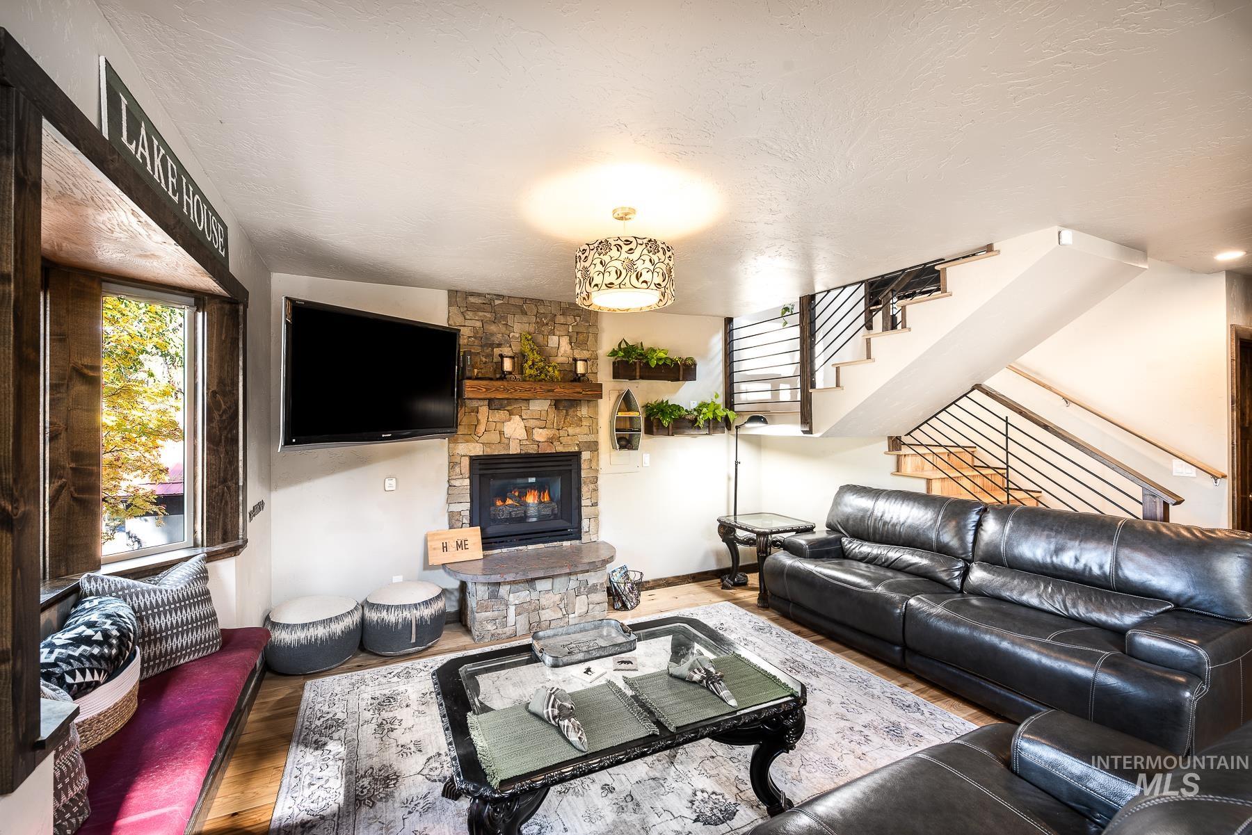 Living area with a fireplace, wood finished floors, and a textured ceiling