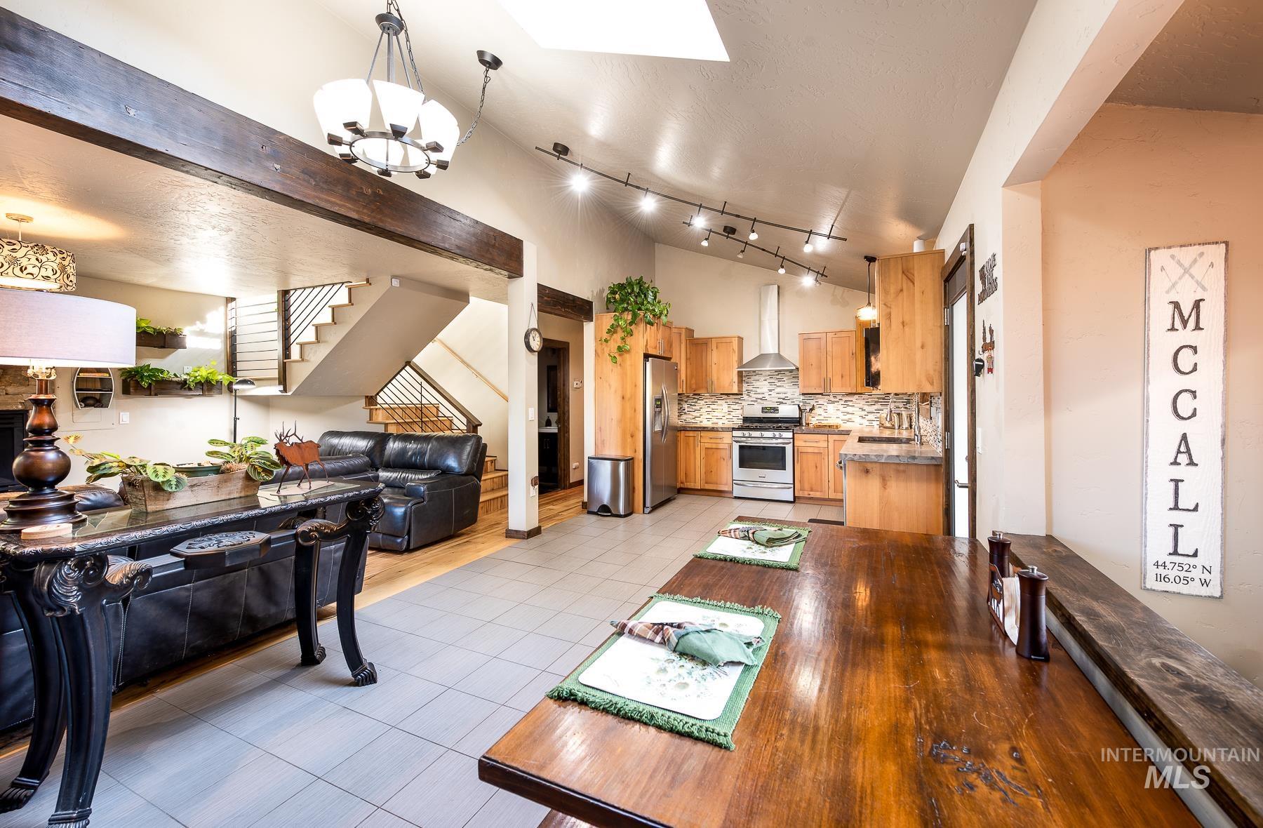 Dining room featuring a skylight, light tile patterned floors, and suspended lighting