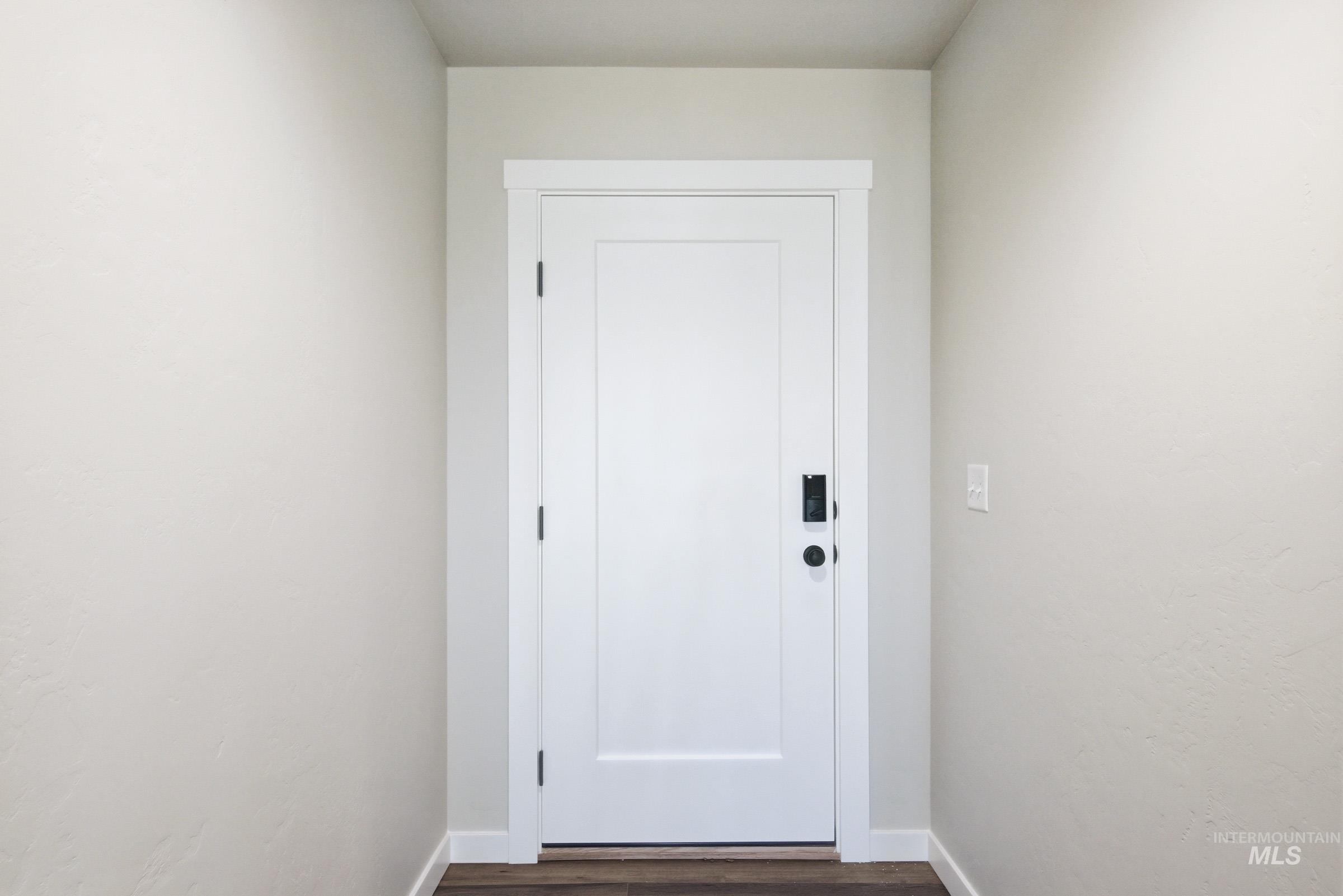 White flat-panel door featuring a contemporary matte black handle and a smart lock system