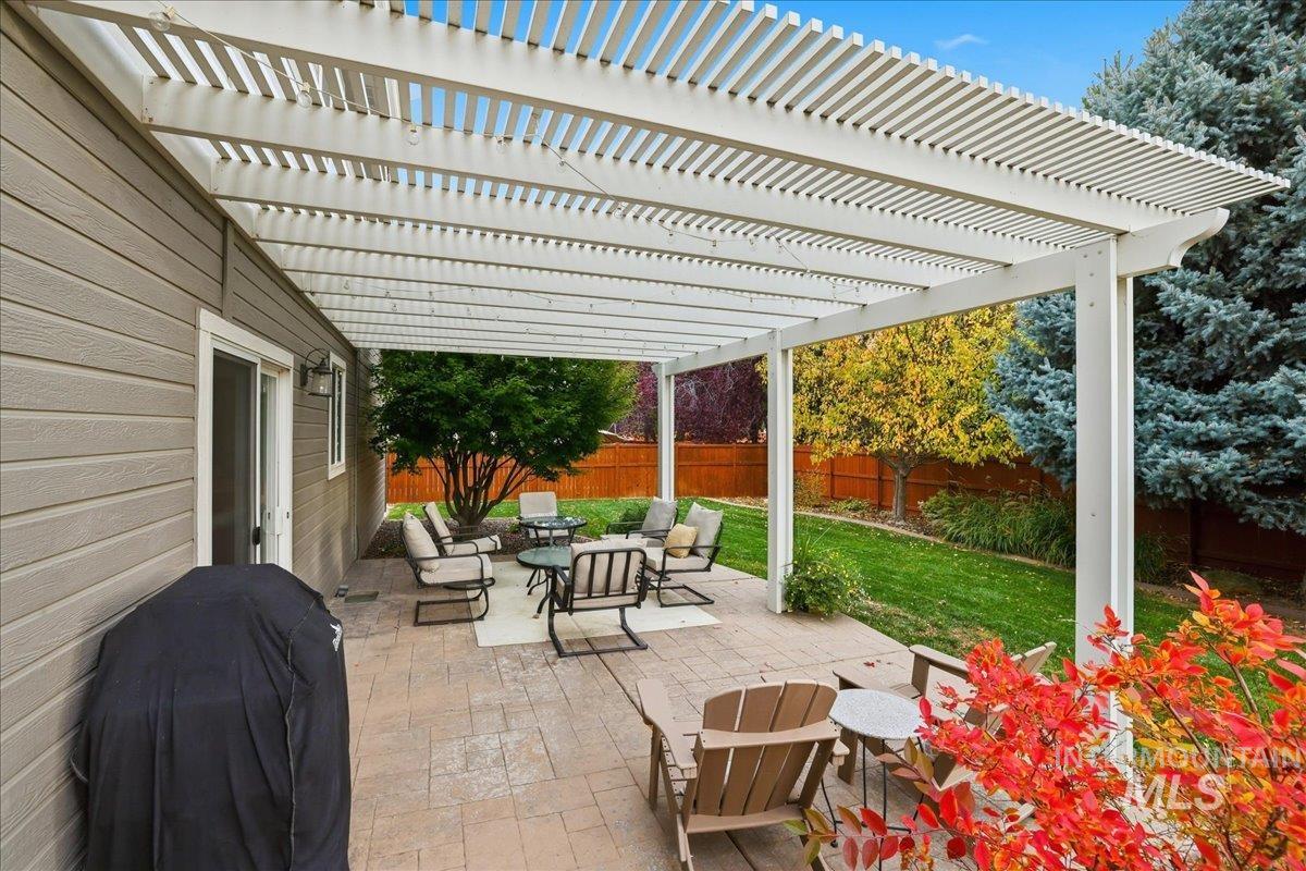 Fenced backyard with a patio area, outdoor dining space, area for grilling, and a pergola