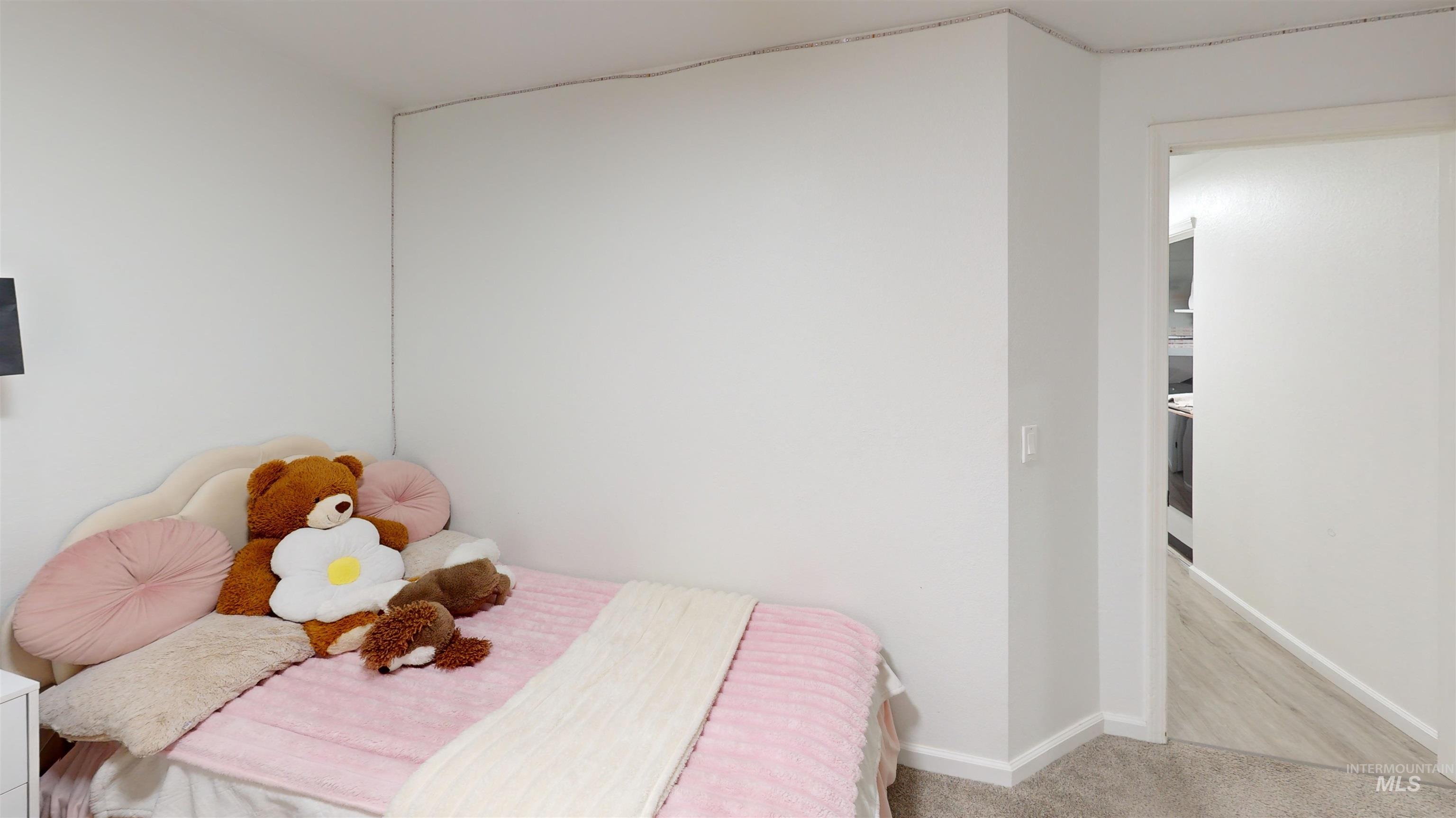 Bedroom featuring baseboards and light colored carpet