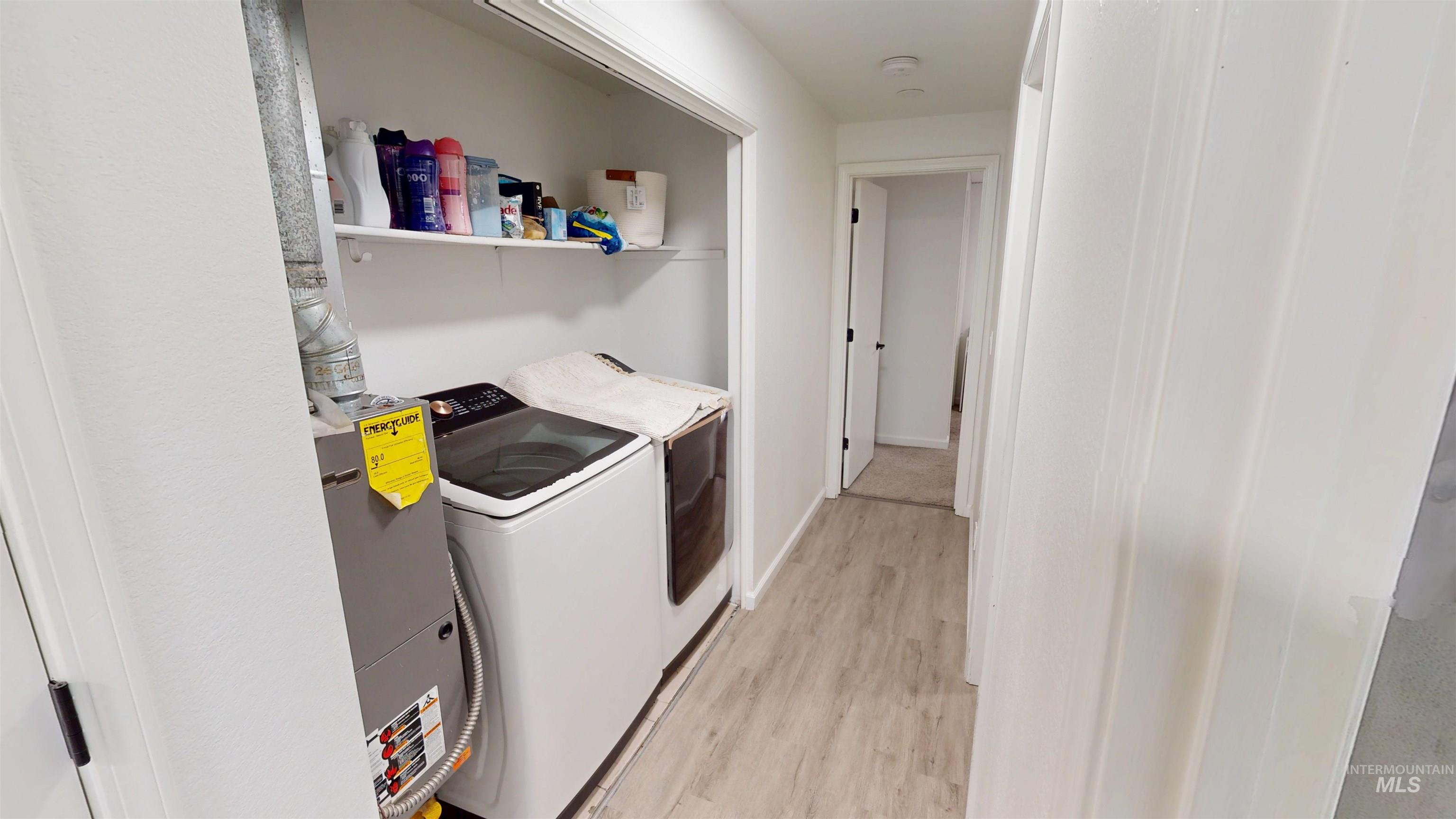 Laundry area featuring light wood-style floors and washer and dryer