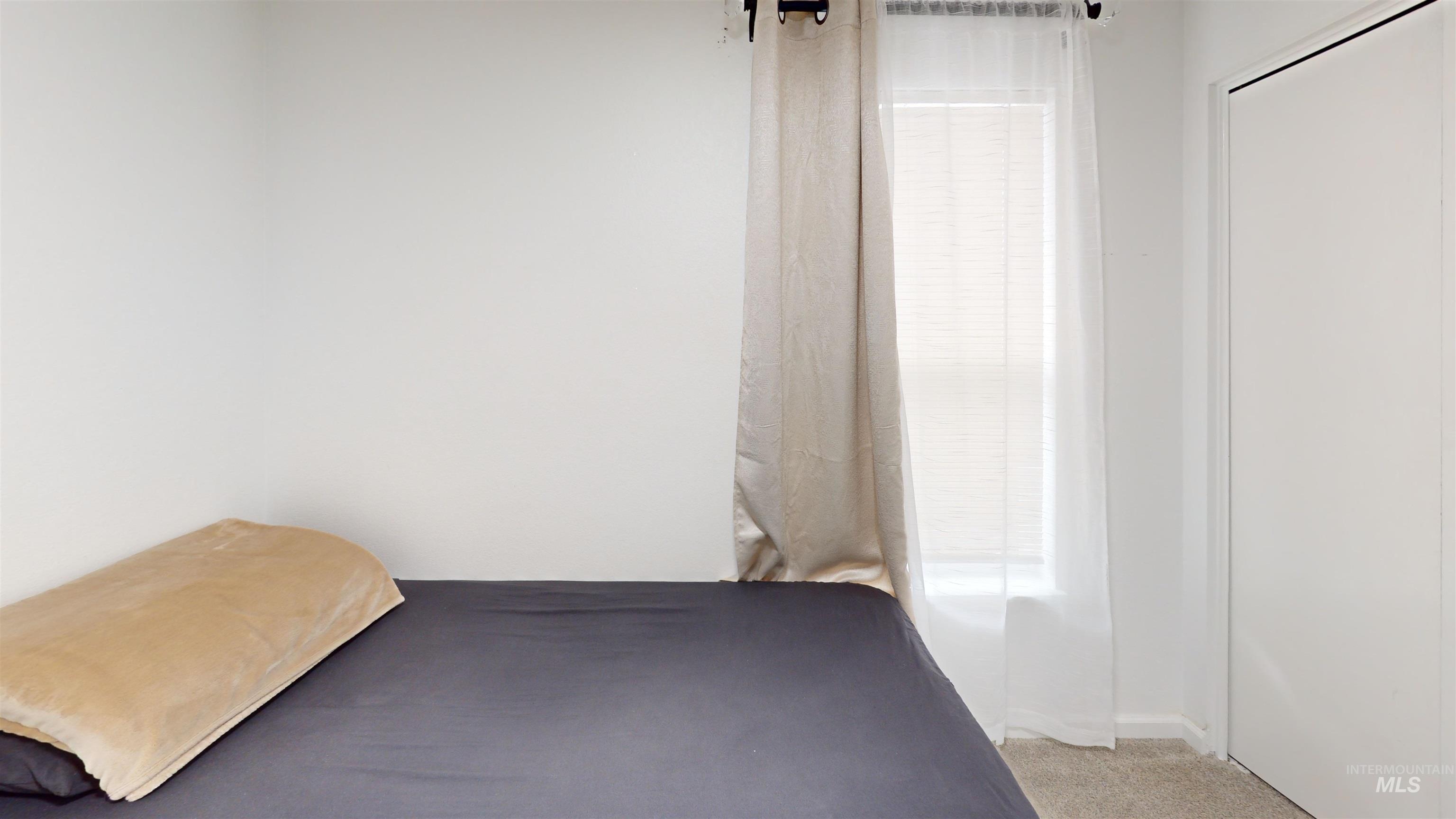 Bedroom featuring light colored carpet