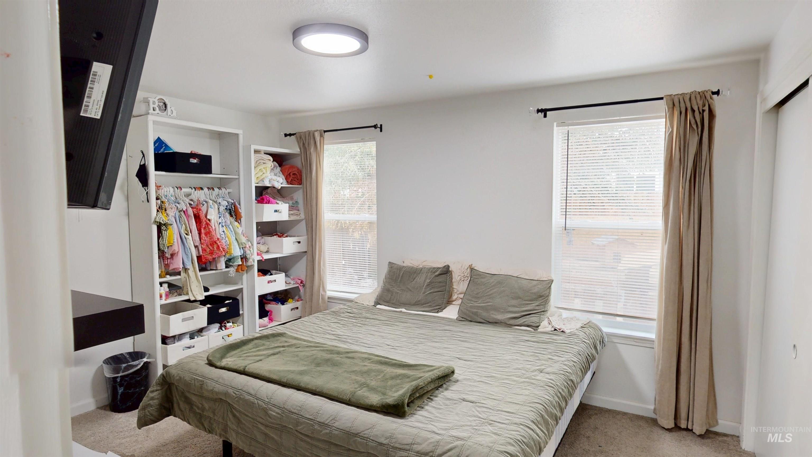 Carpeted bedroom featuring a closet and baseboards