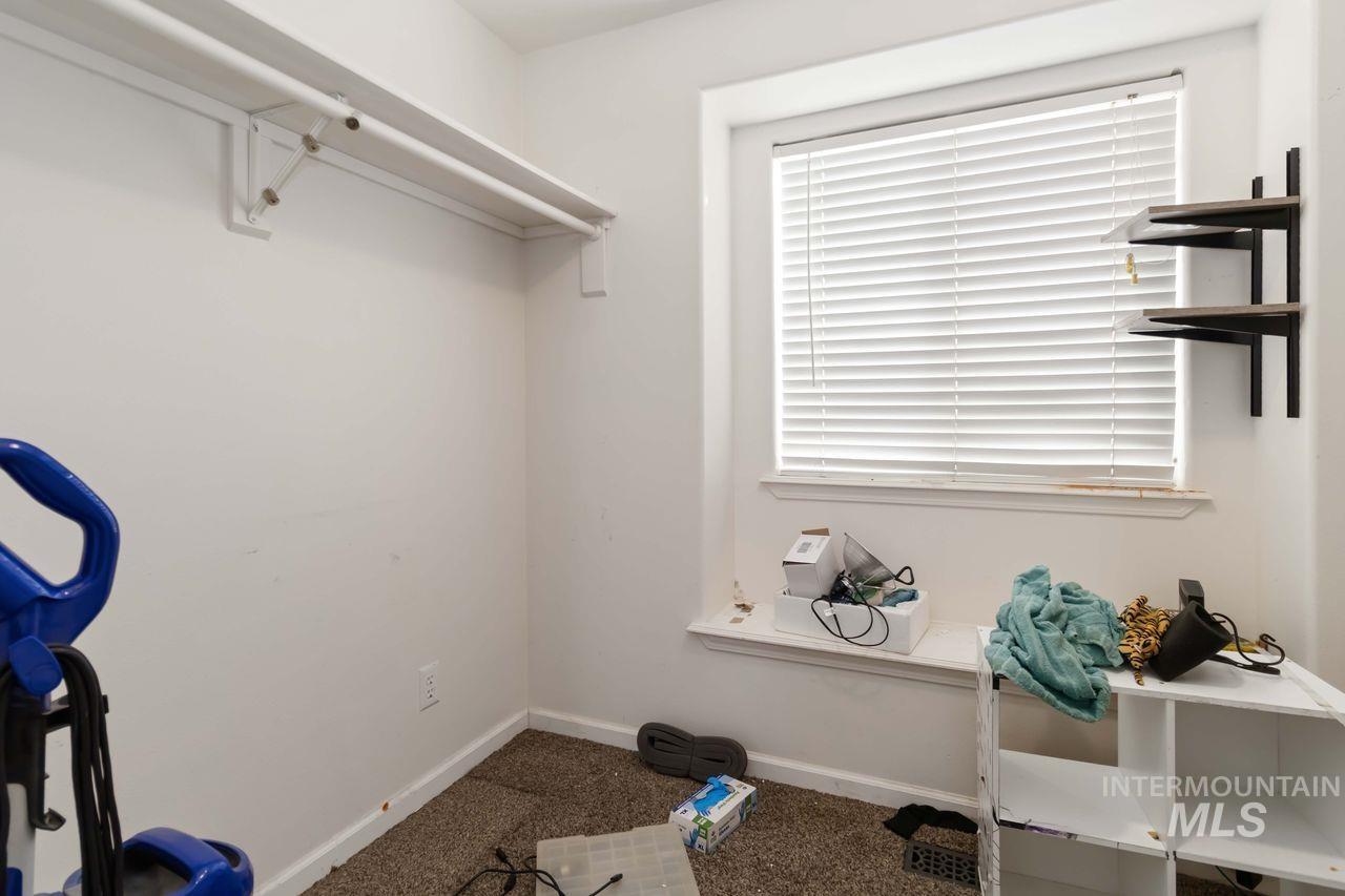 Walk in closet with dark colored carpet