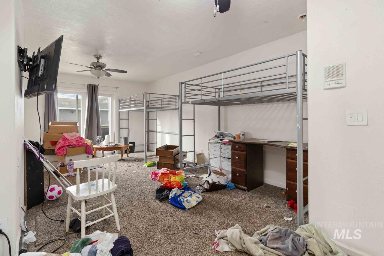 Bedroom with dark colored carpet and a crib