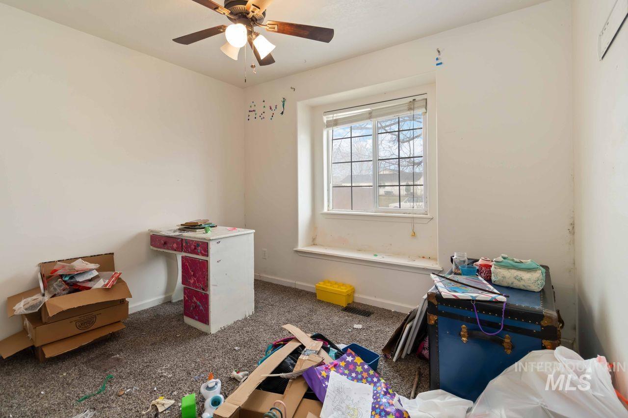 Playroom featuring a ceiling fan and dark carpet