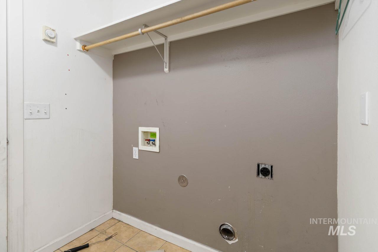 Laundry room featuring washer hookup, light tile patterned floors, and hookup for an electric dryer