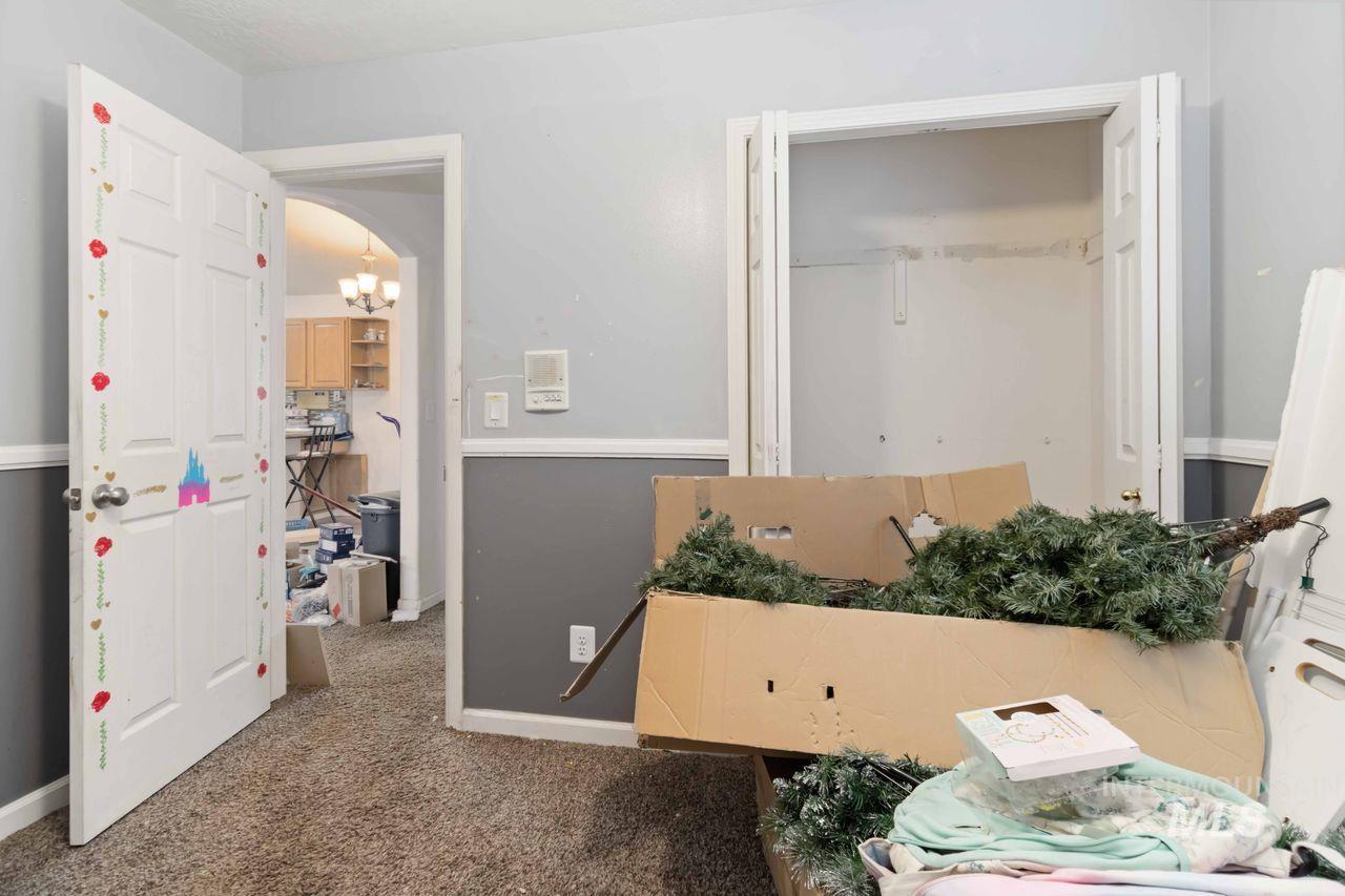 Carpeted bedroom featuring arched walkways and hanging lights