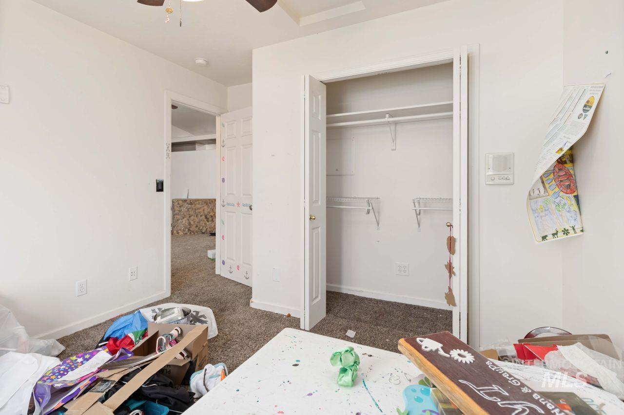 Bedroom featuring dark colored carpet, a closet, and ceiling fan