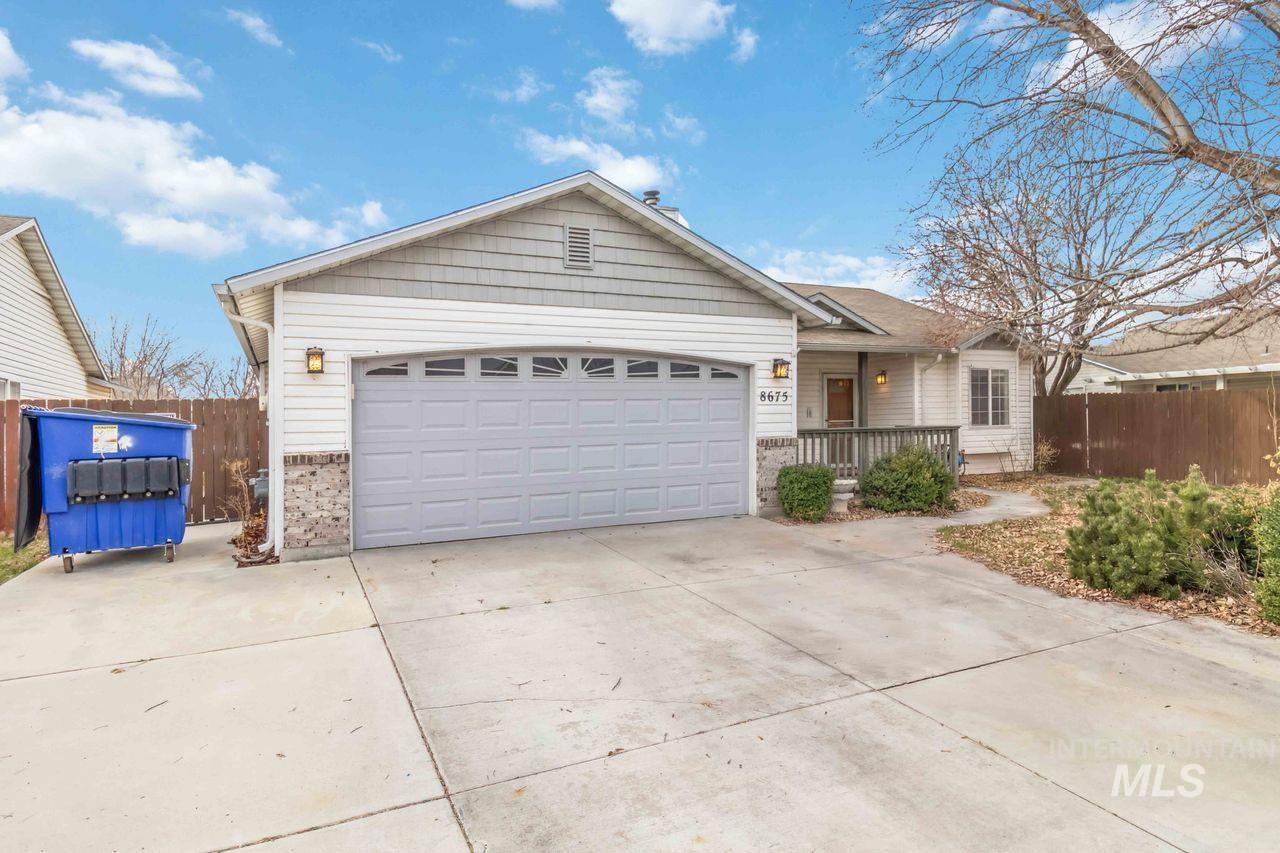 Single story home featuring concrete driveway, an attached garage, and covered porch