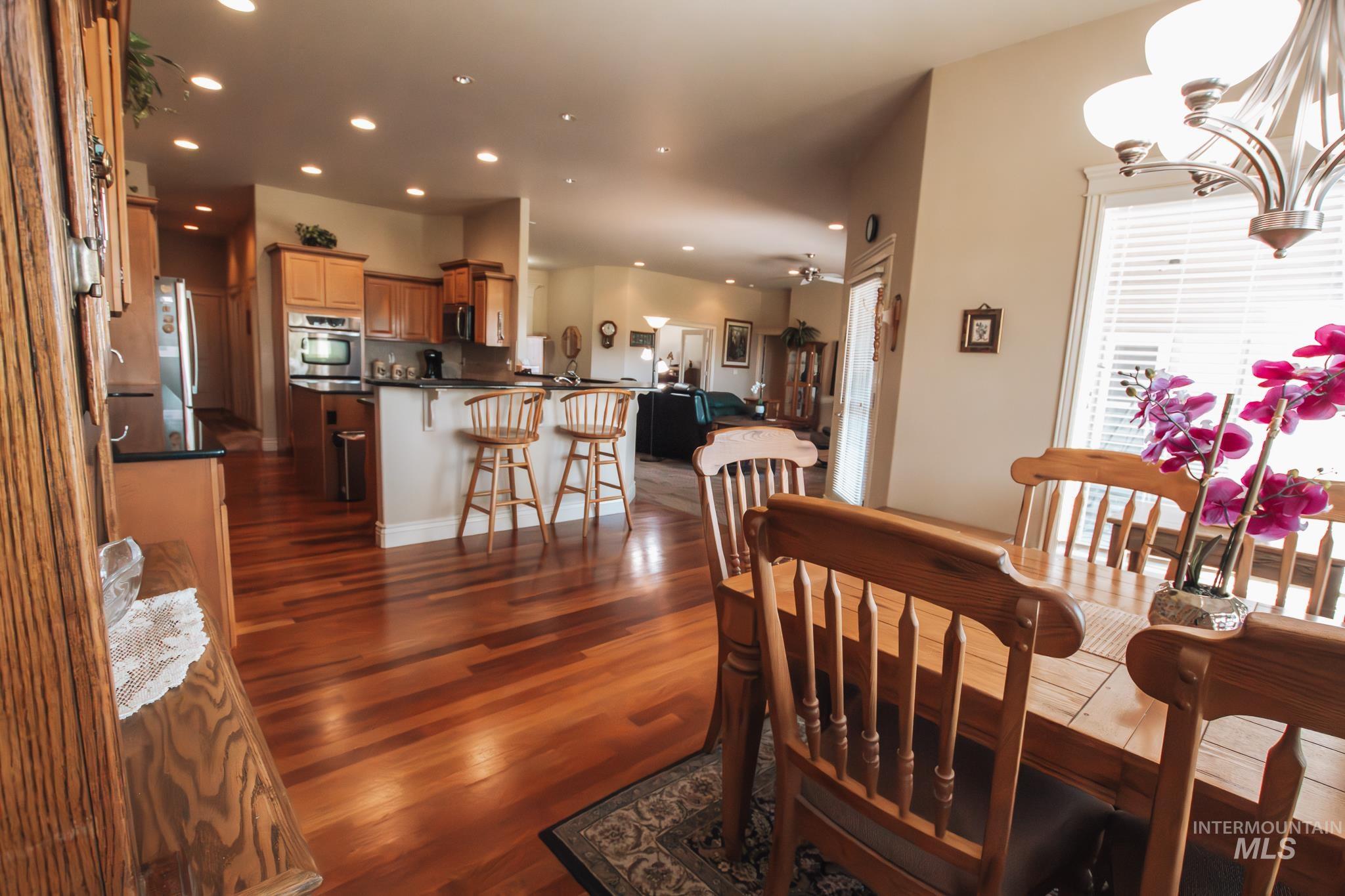 Dining space featuring dark wood-style flooring, recessed lighting, and a chandelier