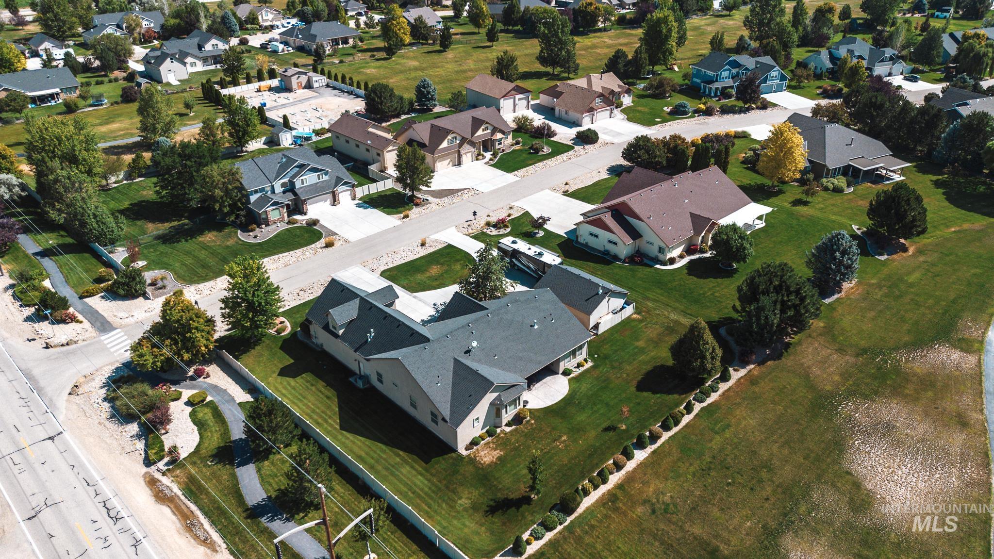 Aerial view of property and surrounding area featuring nearby suburban area